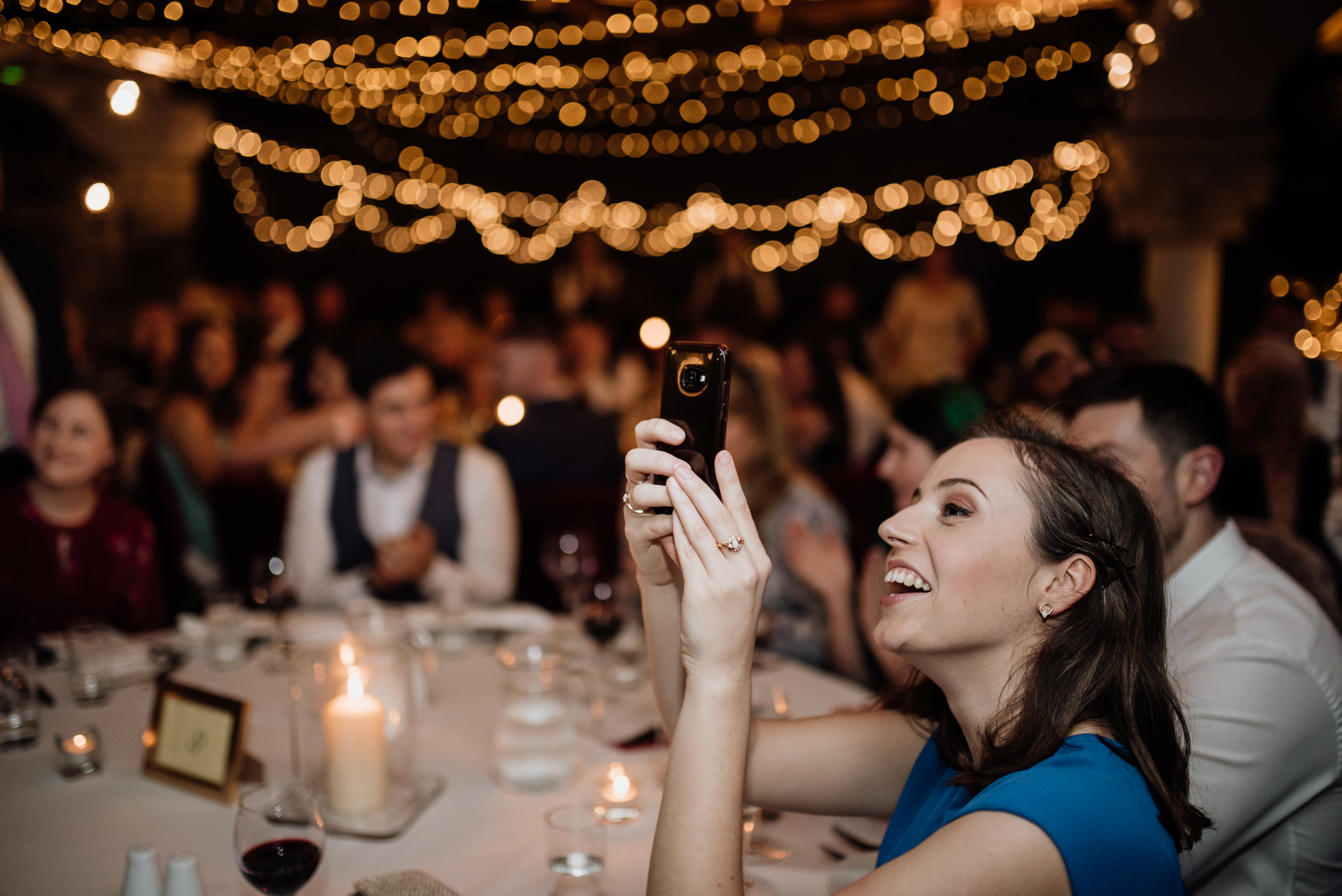 A woman taking a picture of a man holding a cell phone