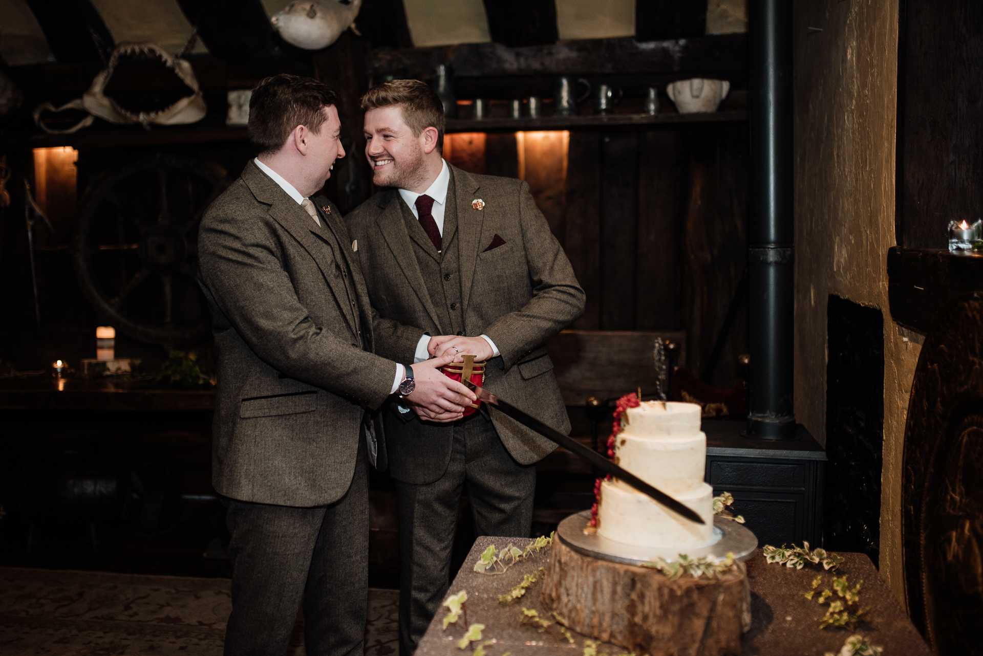 A couple of men cutting a cake