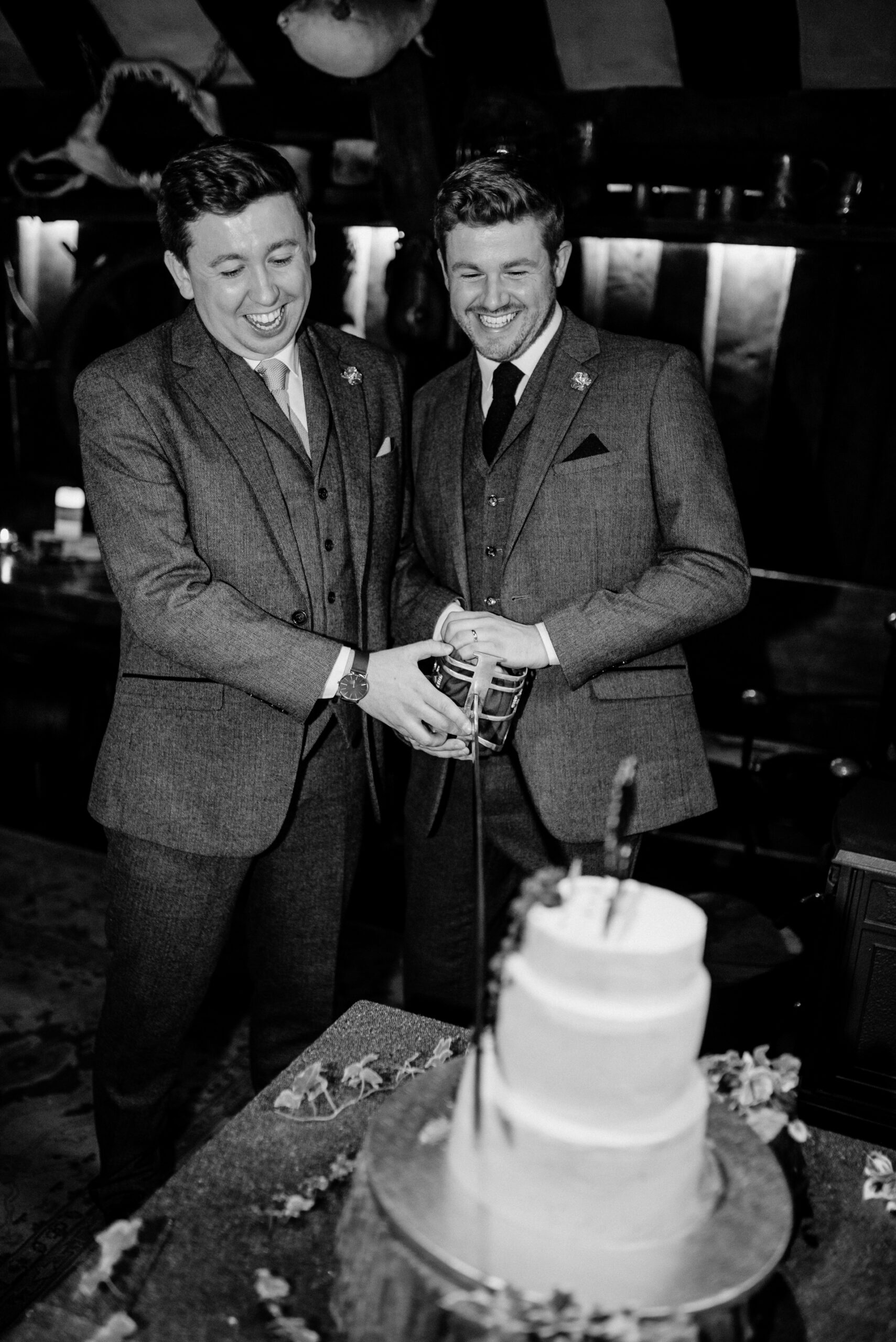 A couple of men cutting a cake