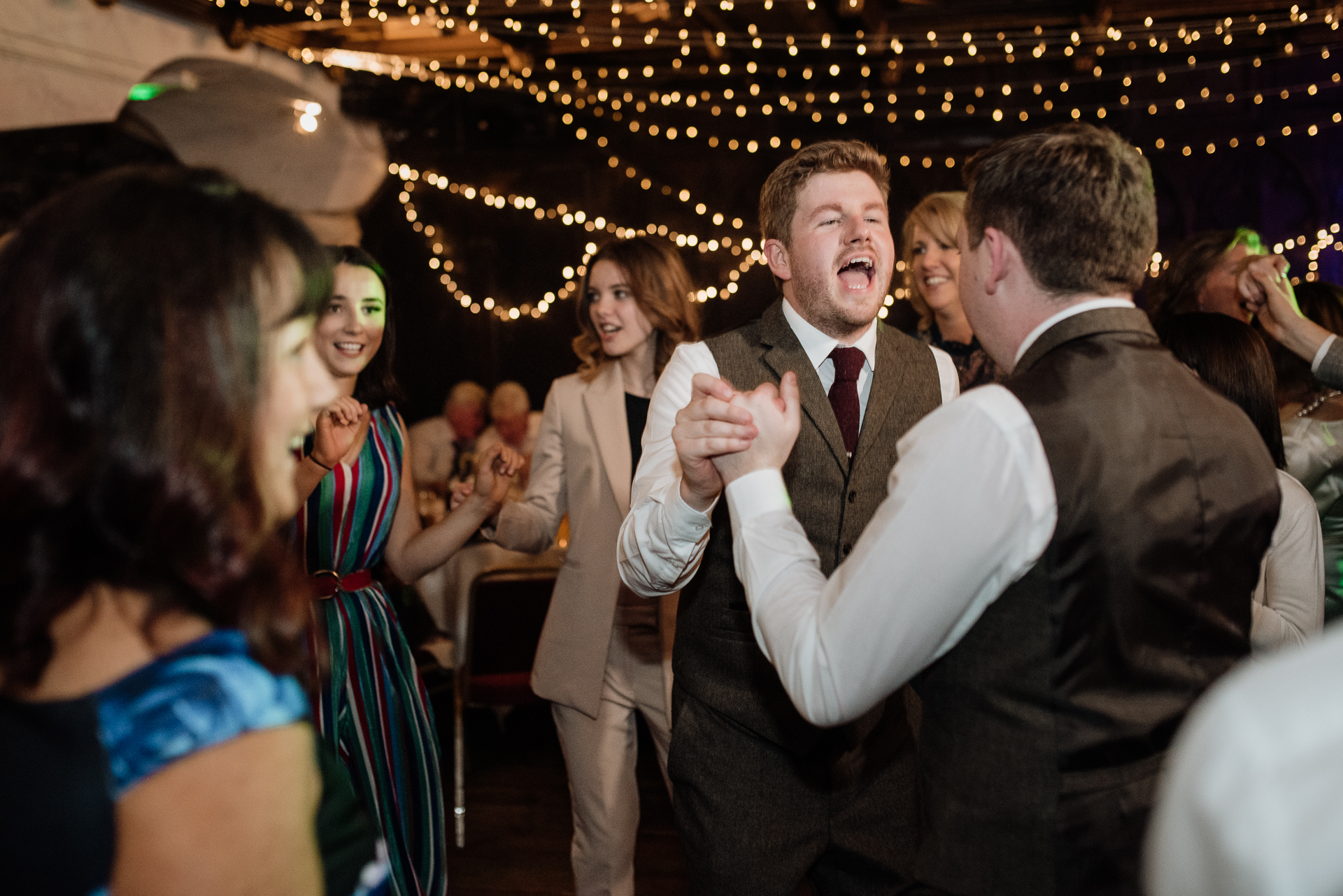 A man in a suit dancing with a crowd of people