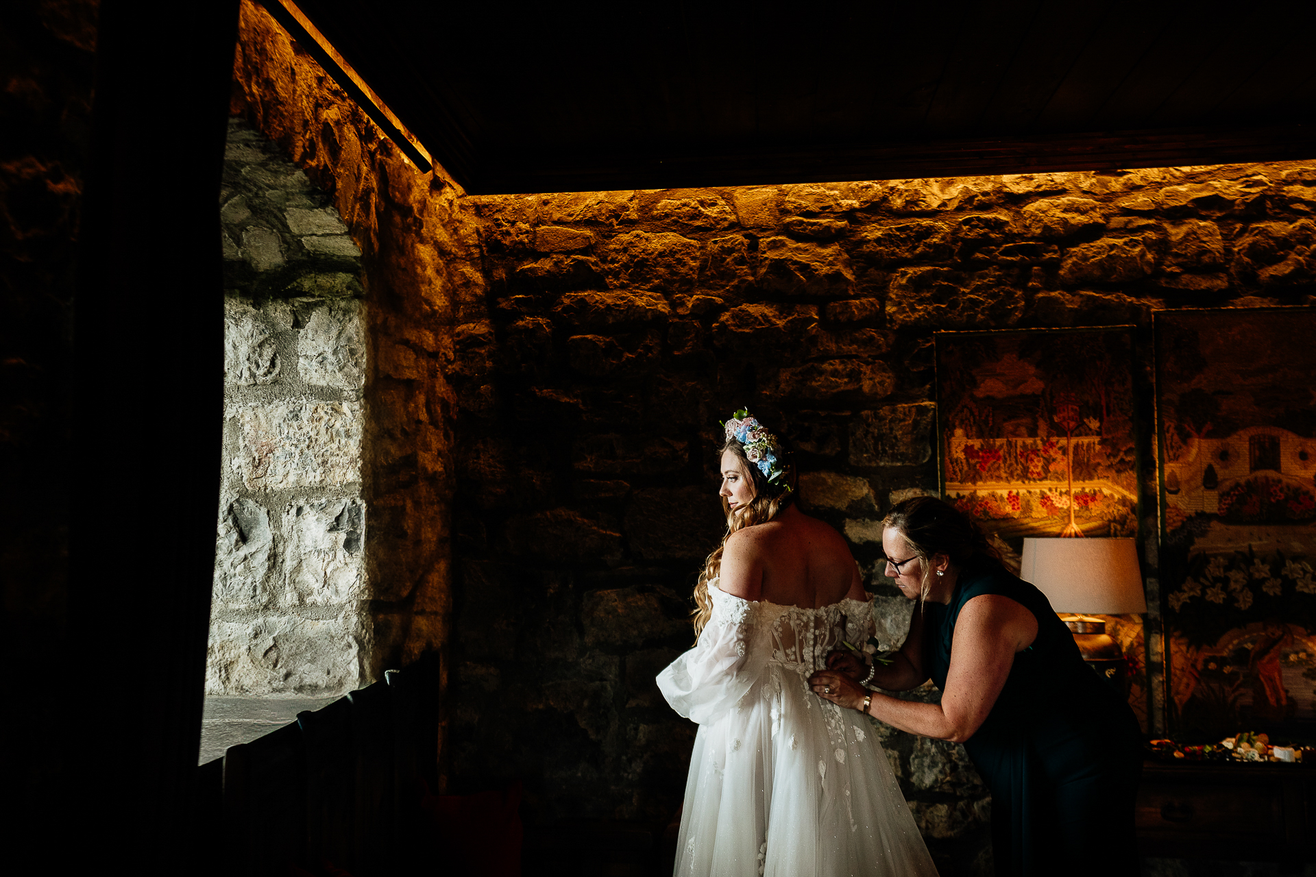 A bride and a groom in a room with a fireplace