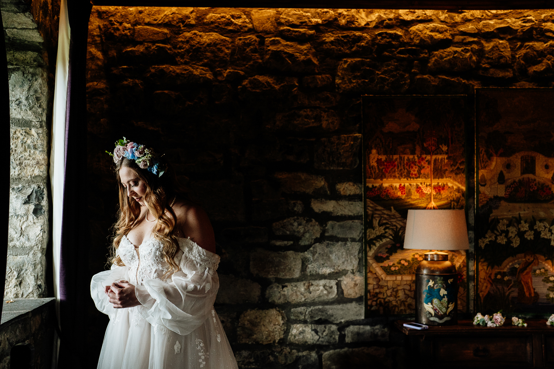 A bride and groom kissing in front of a fireplace