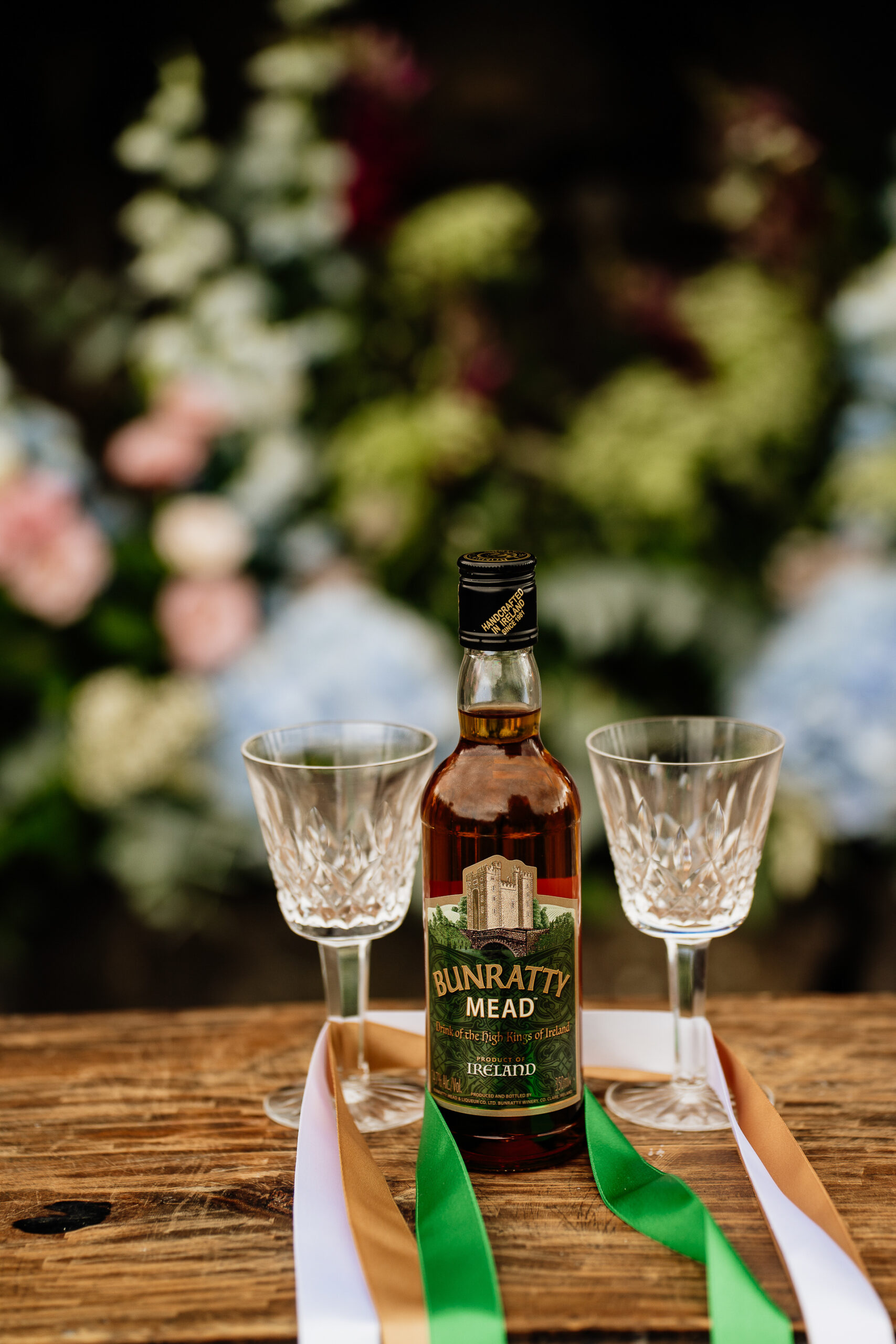 A bottle of alcohol and two empty glasses on a table