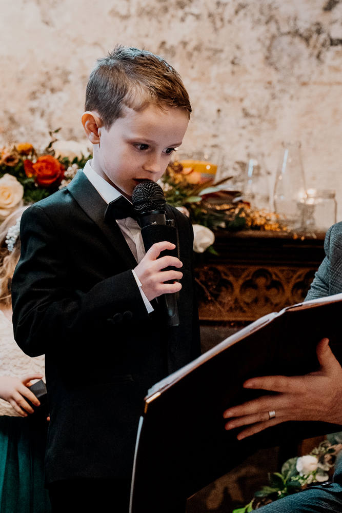 A boy holding a microphone and a book