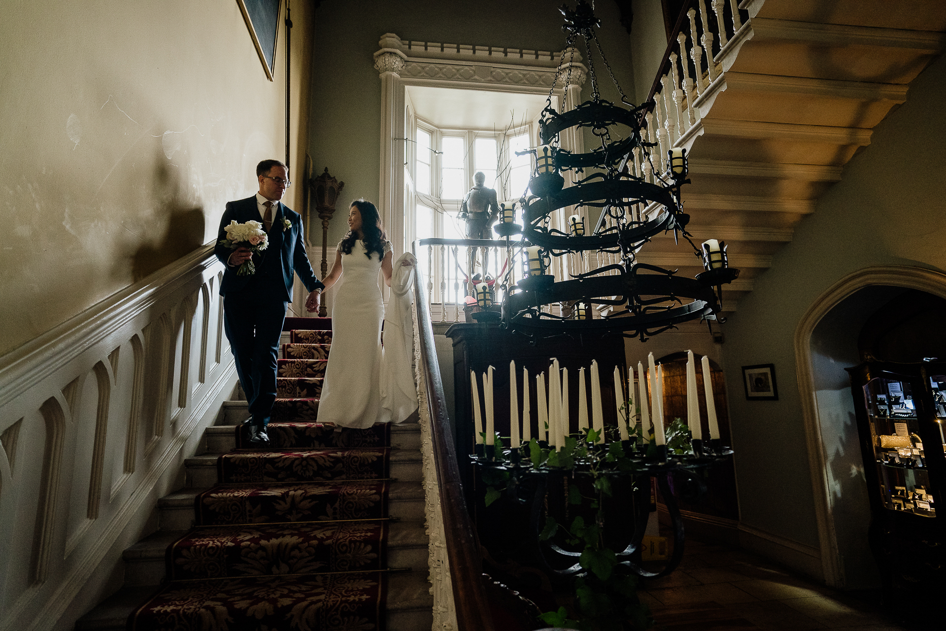 A bride and groom walking down the stairs