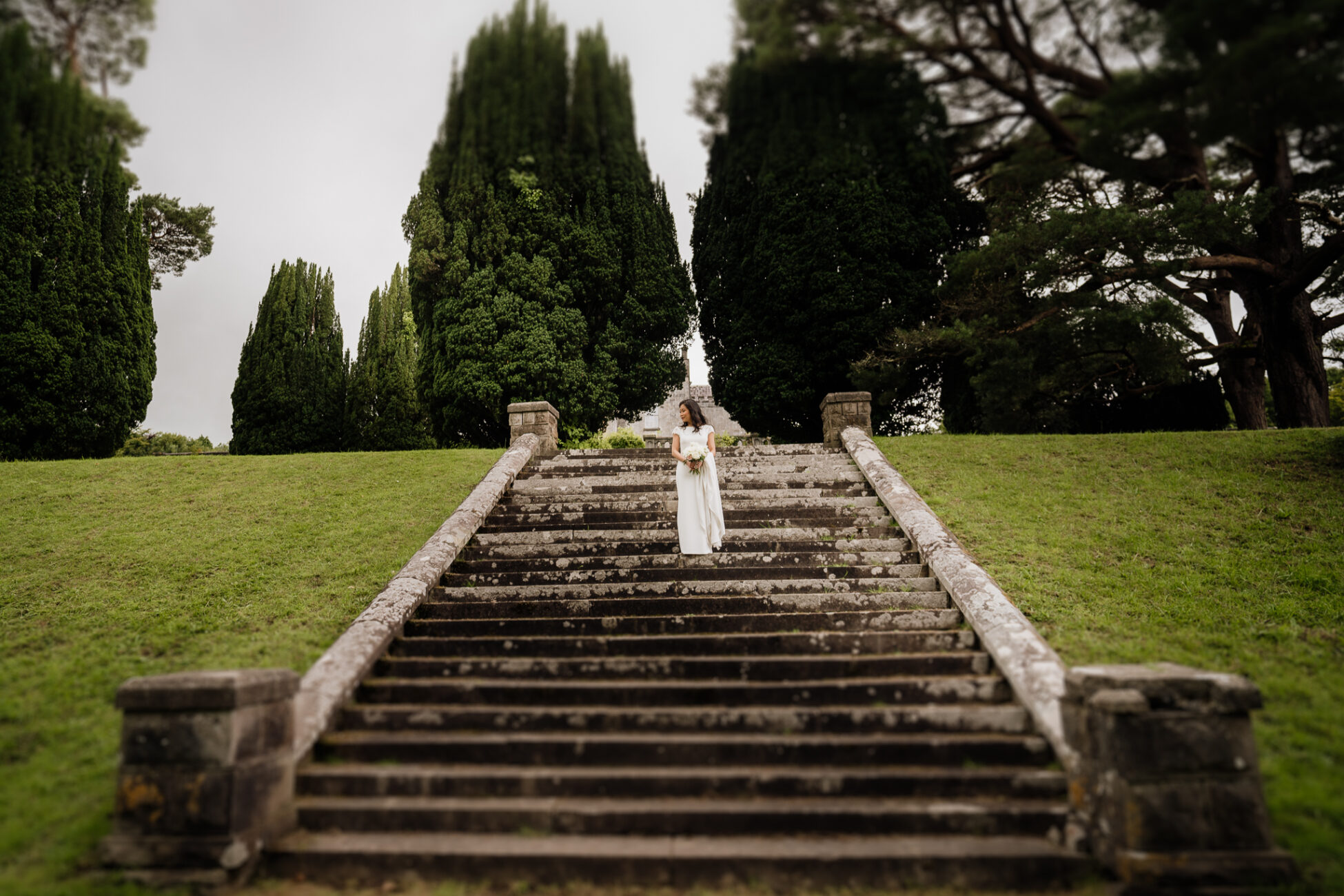 A person standing on a set of stairs with a fountain in the background