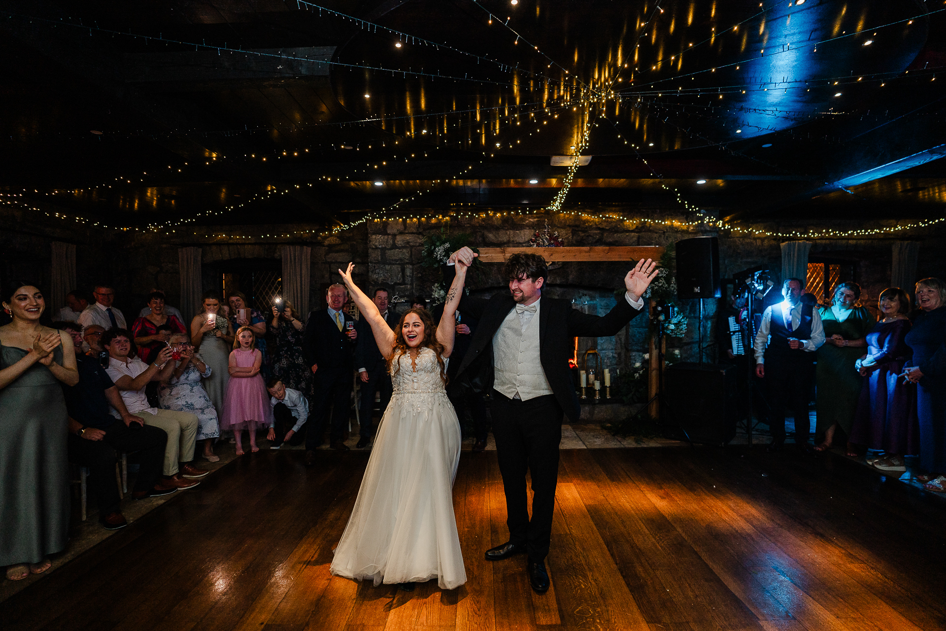 A man and woman dancing on a stage with a crowd watching