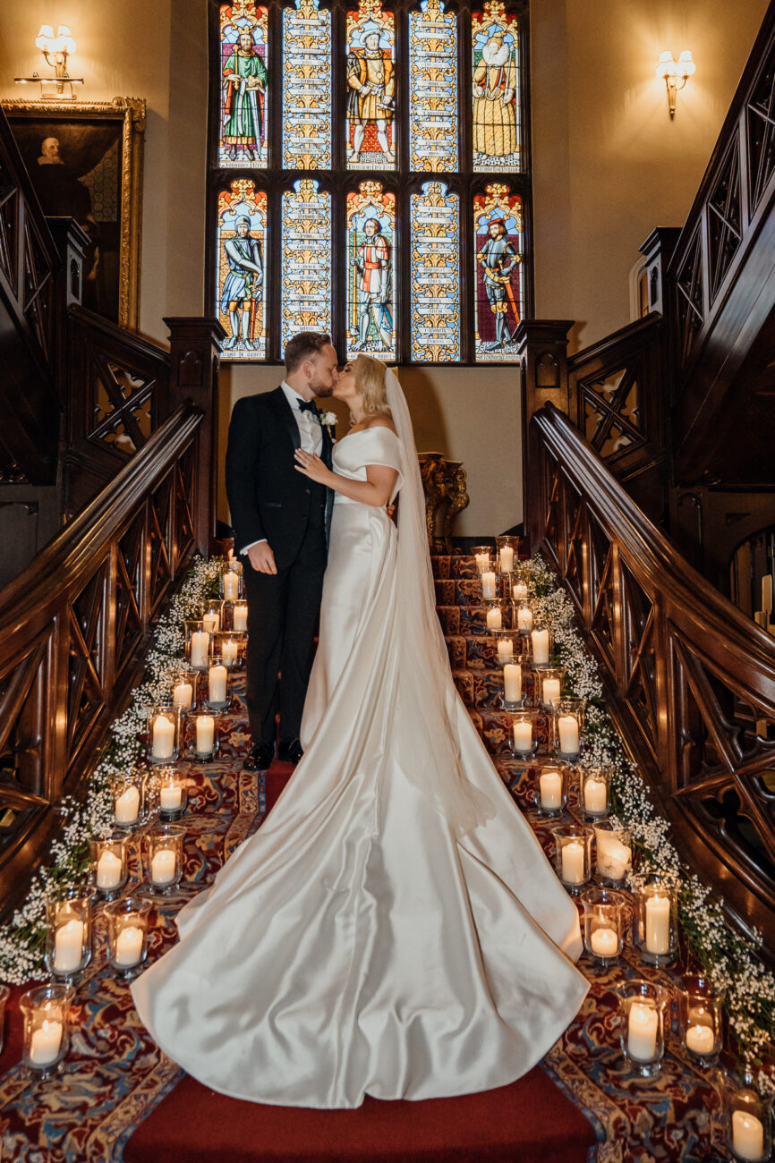 A man and woman in wedding attire on a staircase