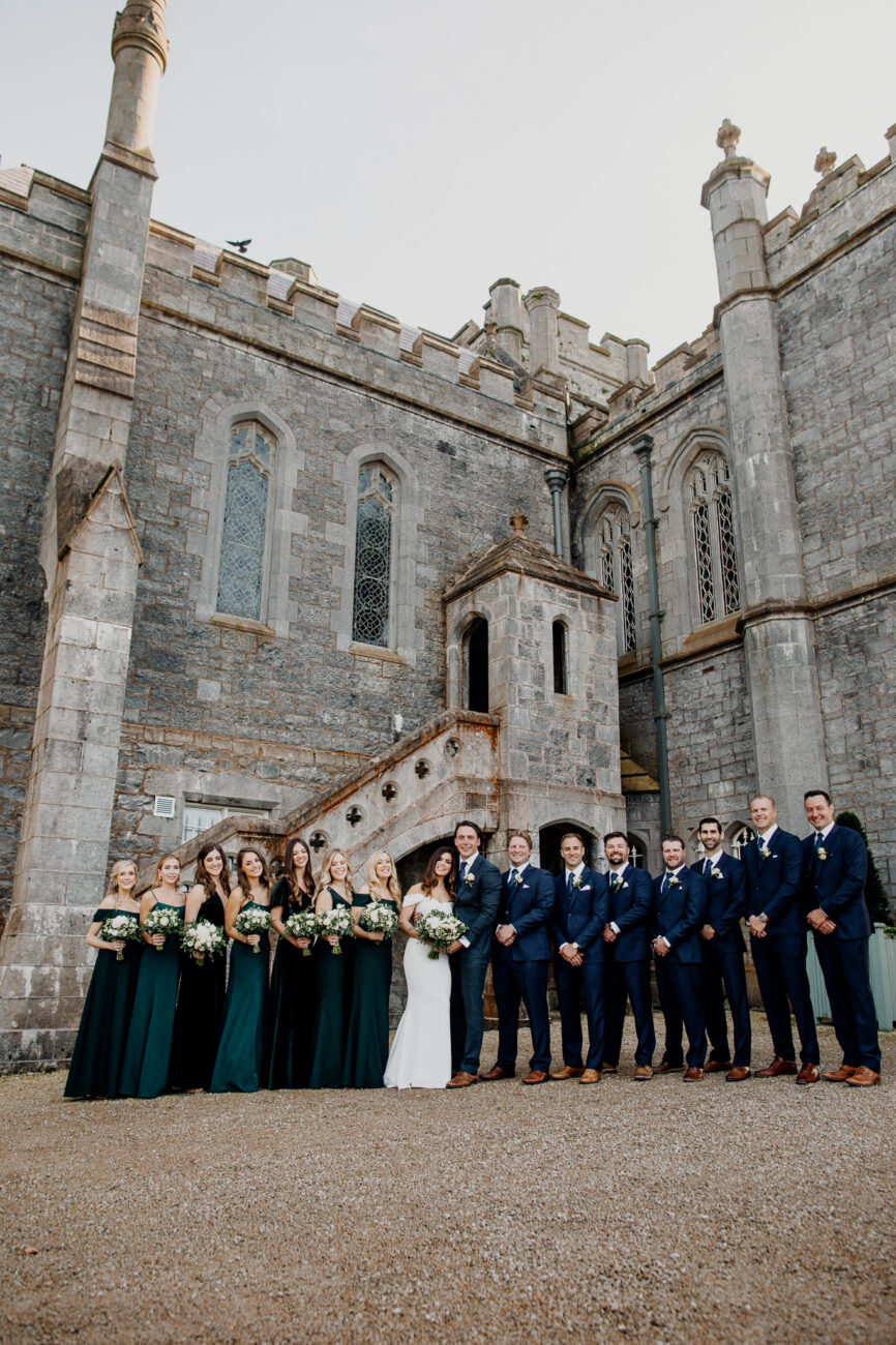 A group of people posing for a photo in front of a stone building