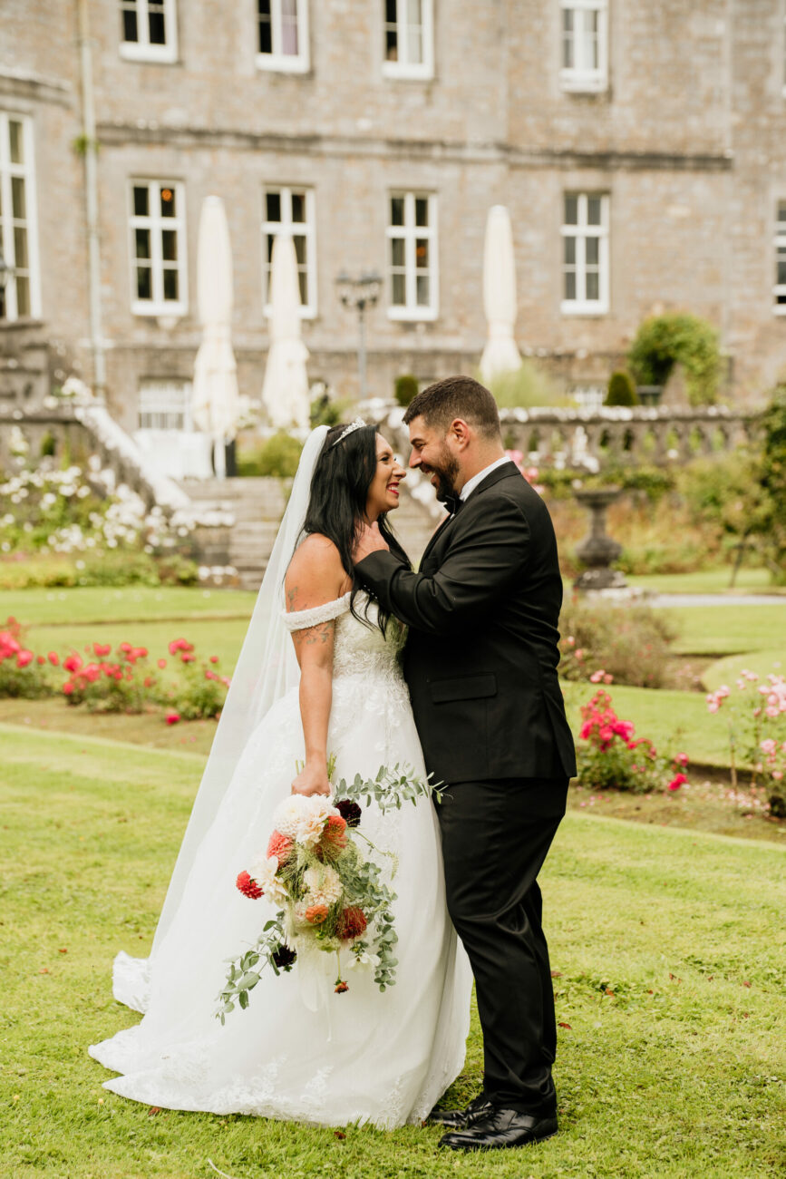 A man and woman kissing in front of a building