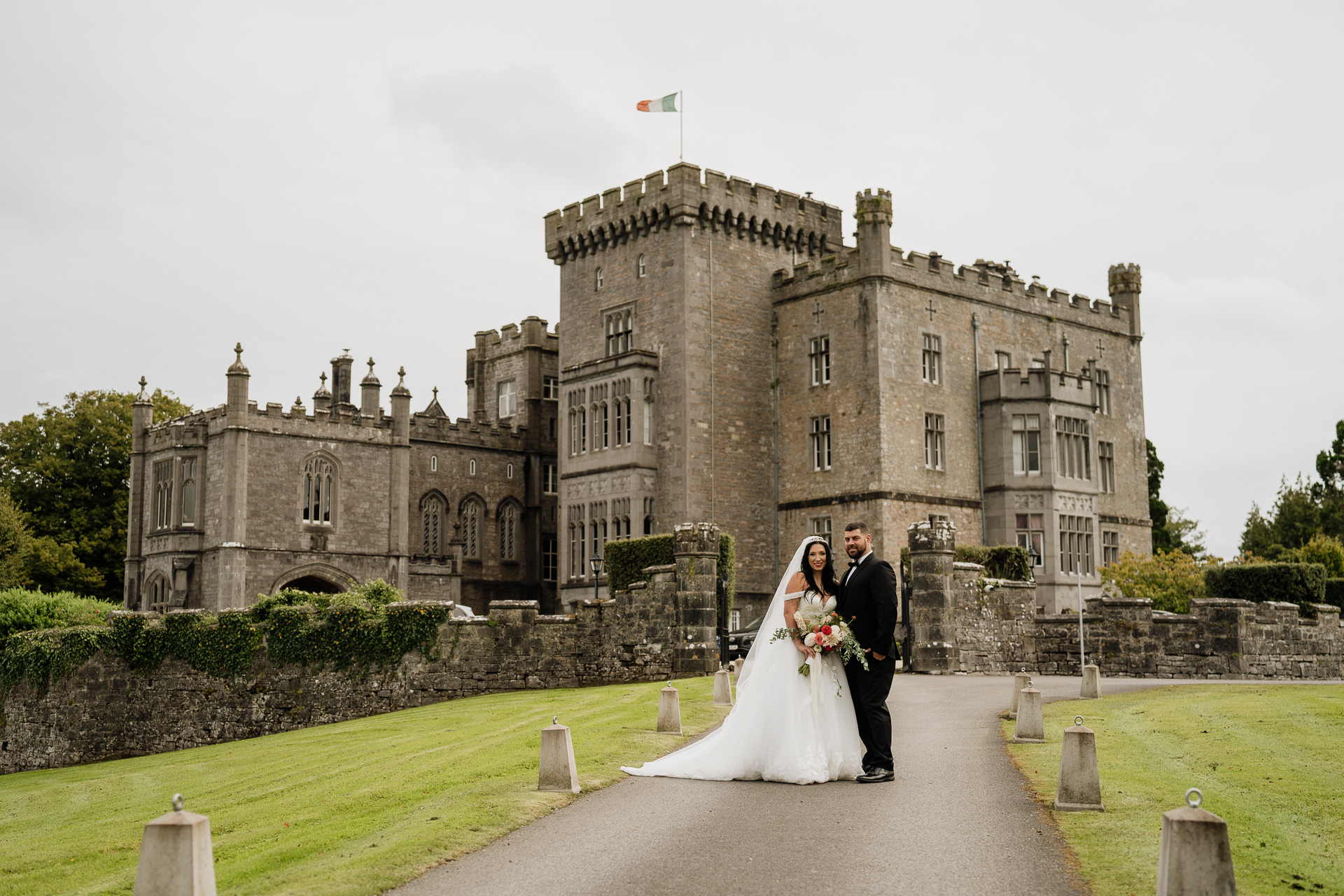 A man and woman in wedding attire in front of a castle