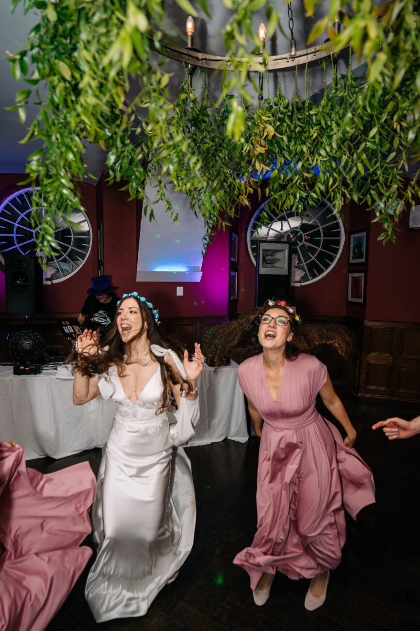 Two women wearing dresses and dancing