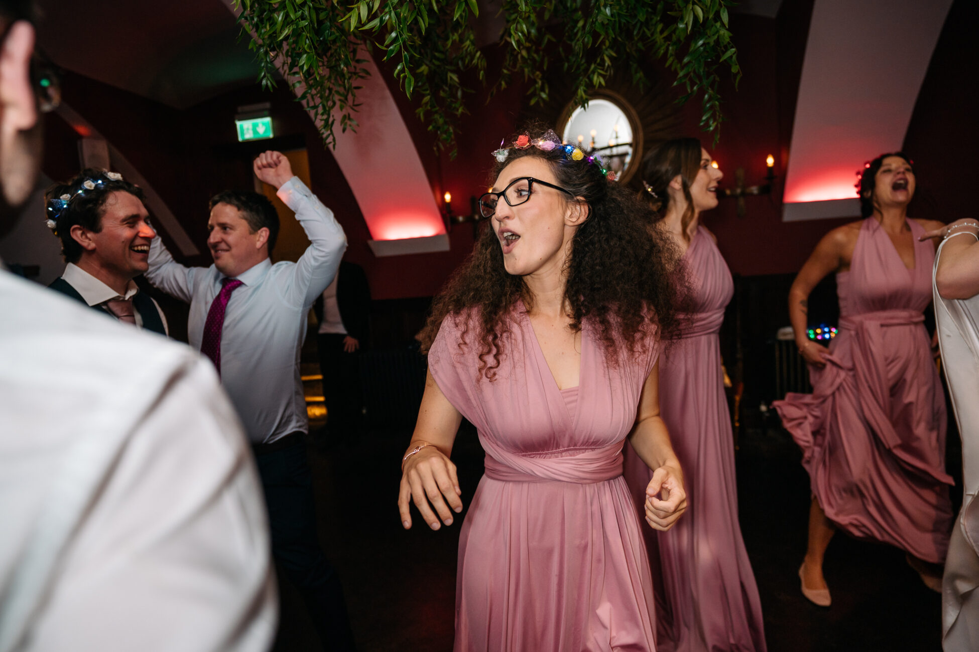 A man in a pink dress dancing with other people