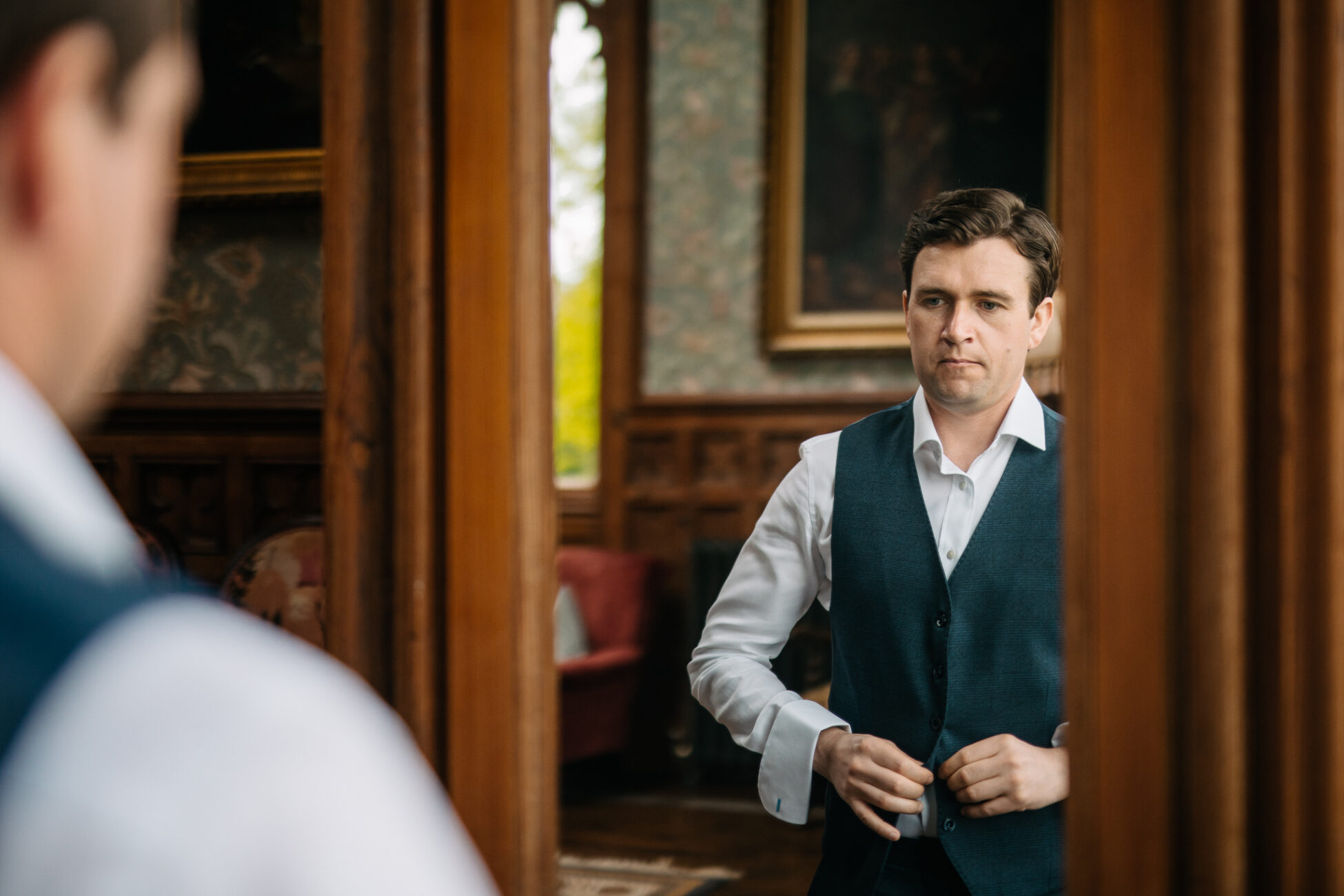 A person in a suit standing in a room with a person in a suit