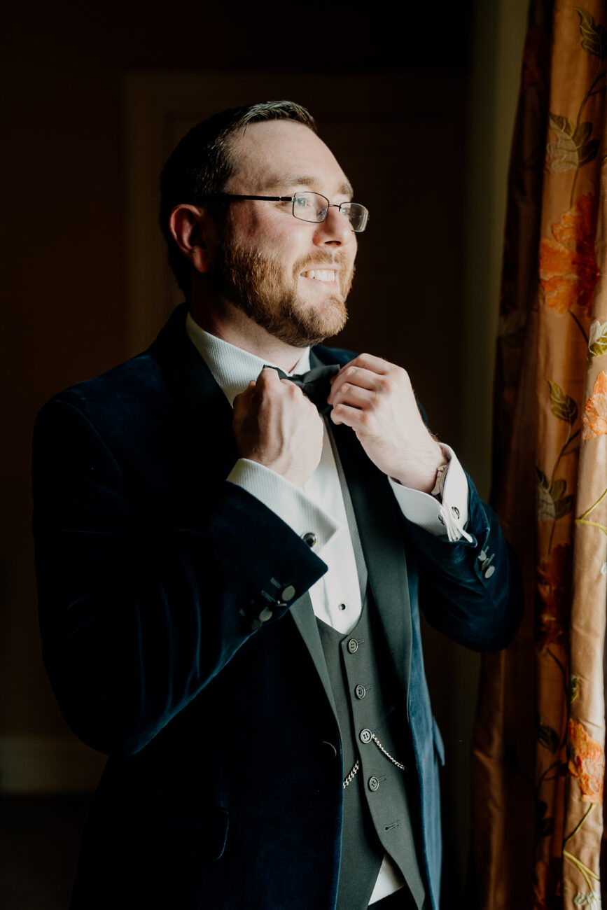 A man in a suit fixing his tie