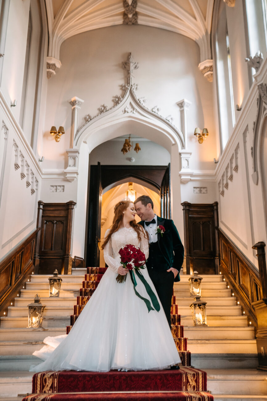 A bride and groom posing on the stairs