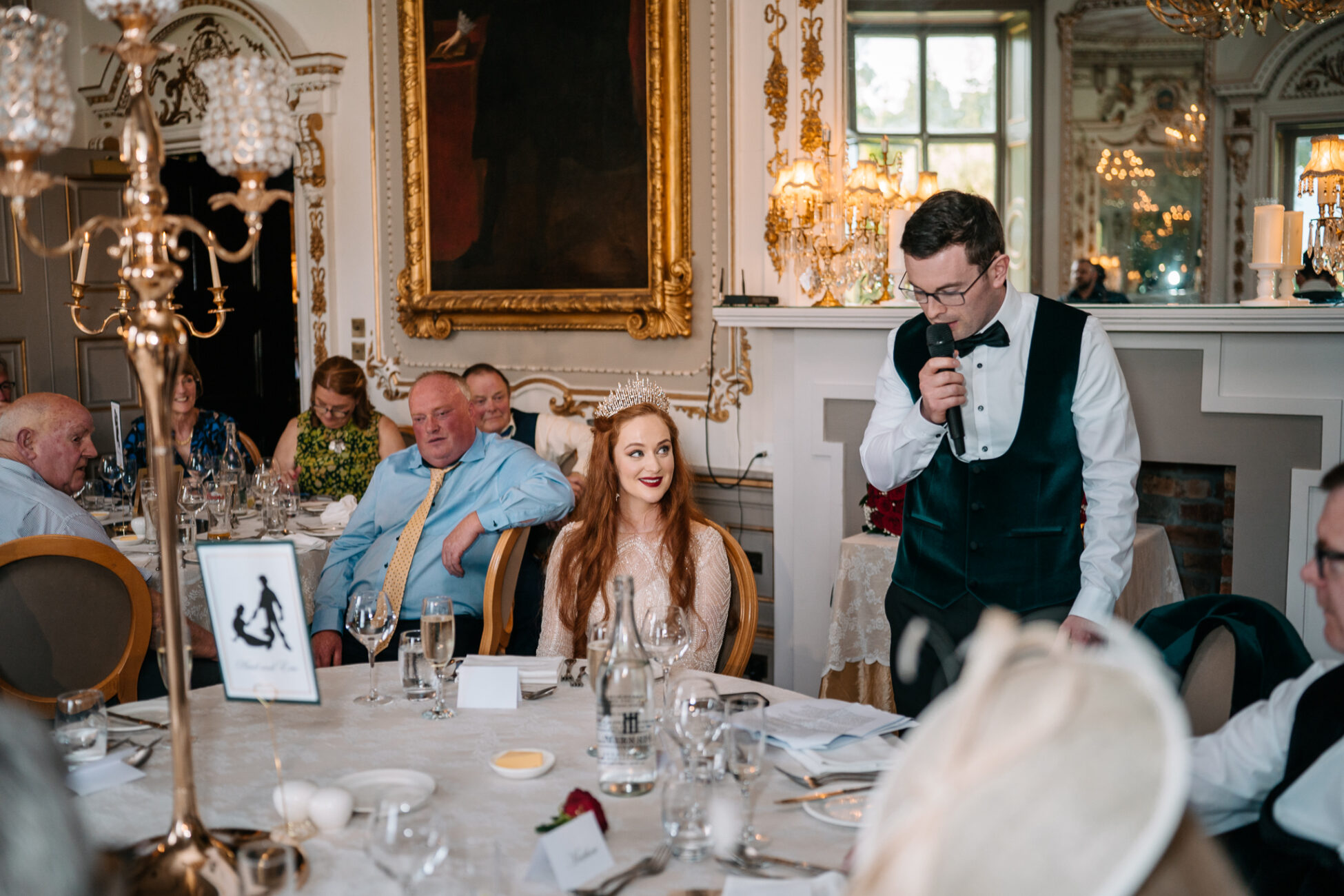 A group of people sitting at a table with a person in a dress