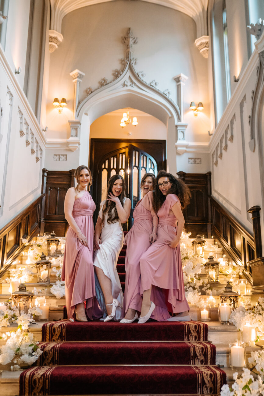 A group of women in dresses standing on a staircase