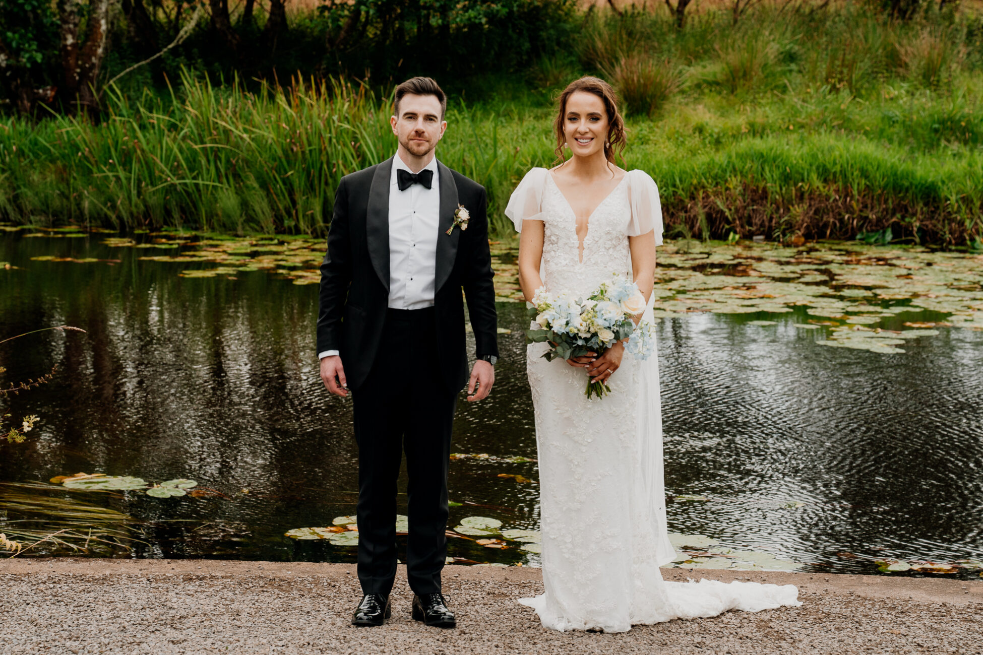 A man and woman posing for a picture next to a pond