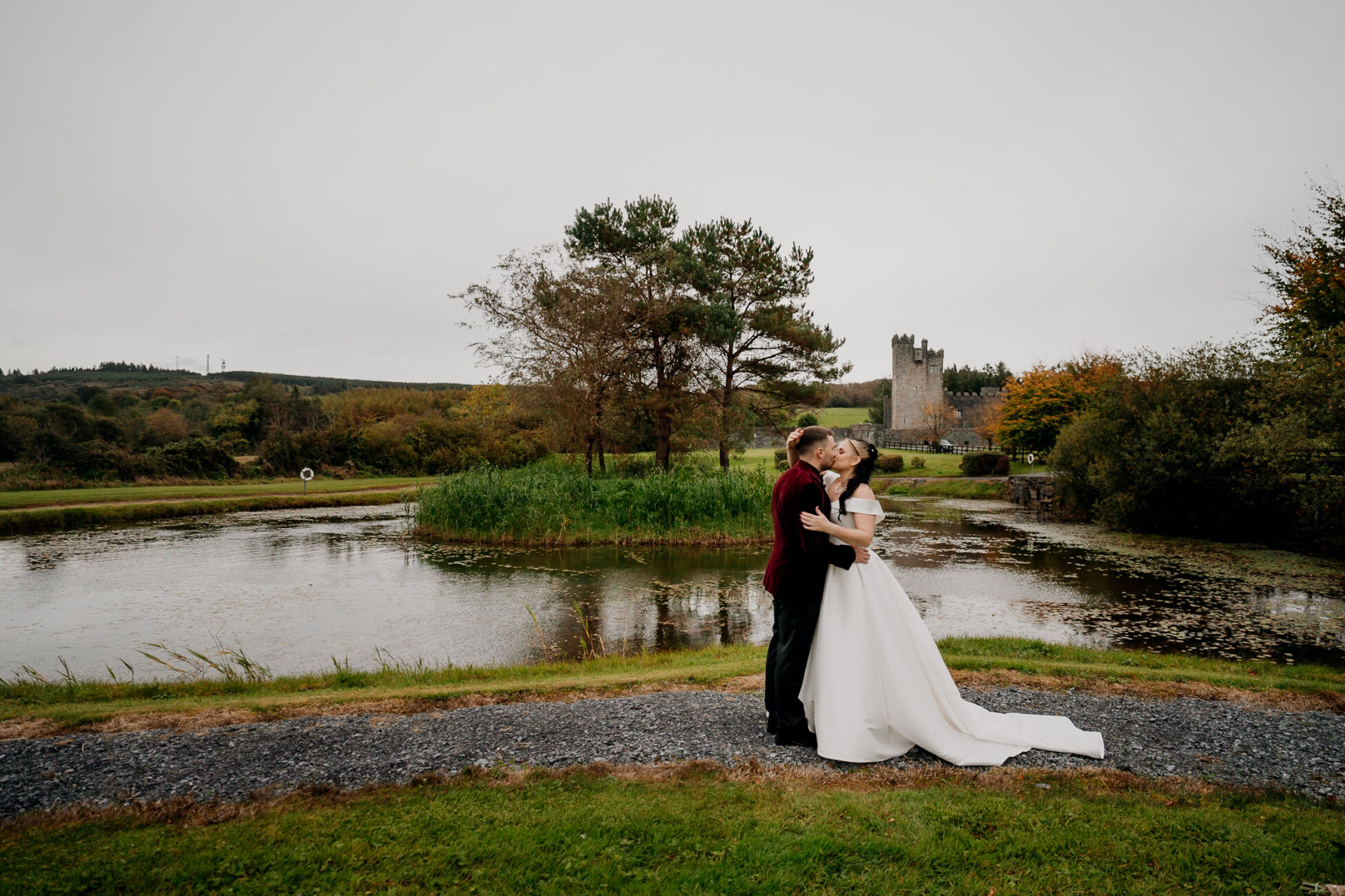 A man and woman kissing by a pond