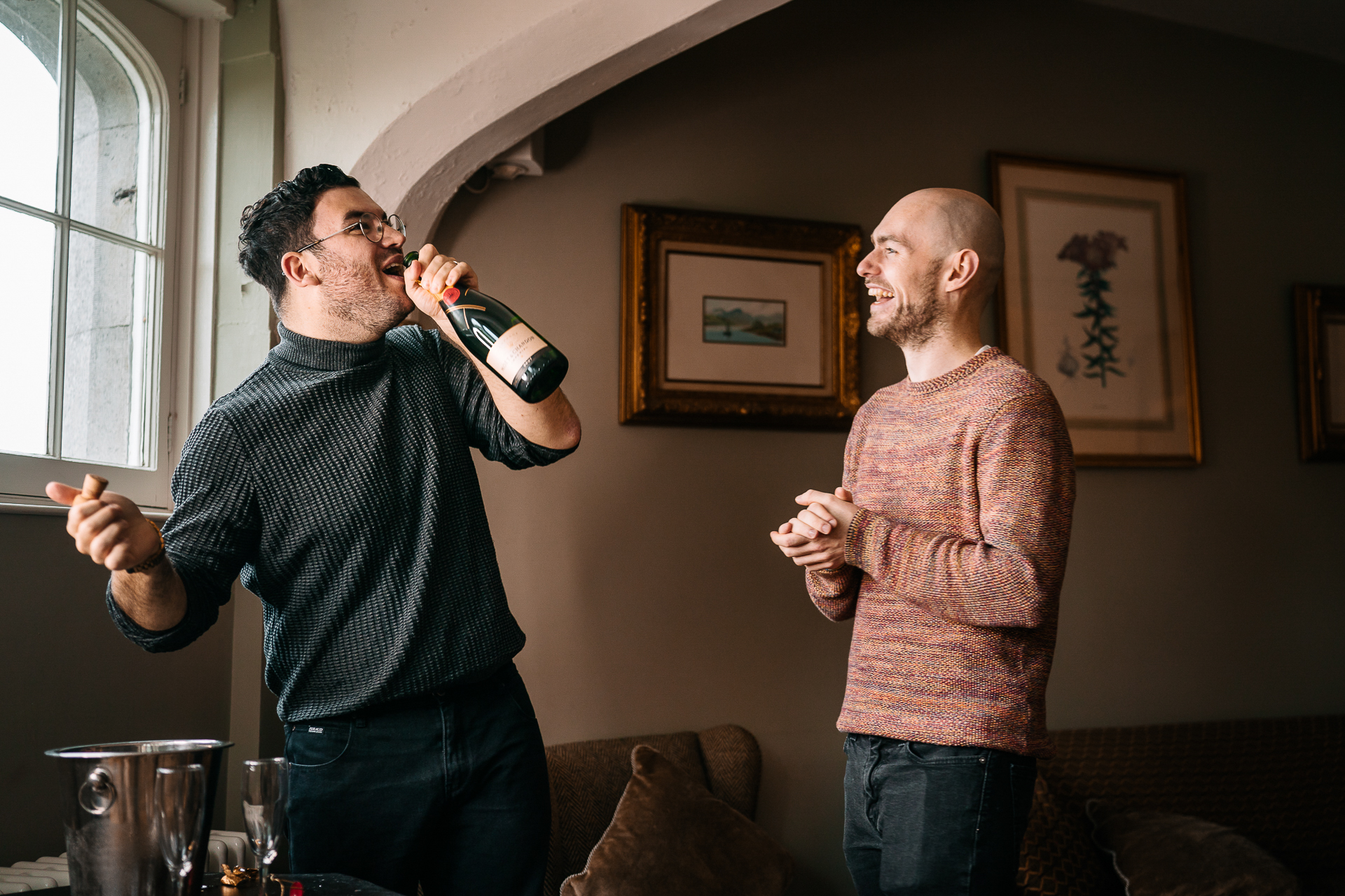 A man holding a microphone and another man holding a bottle