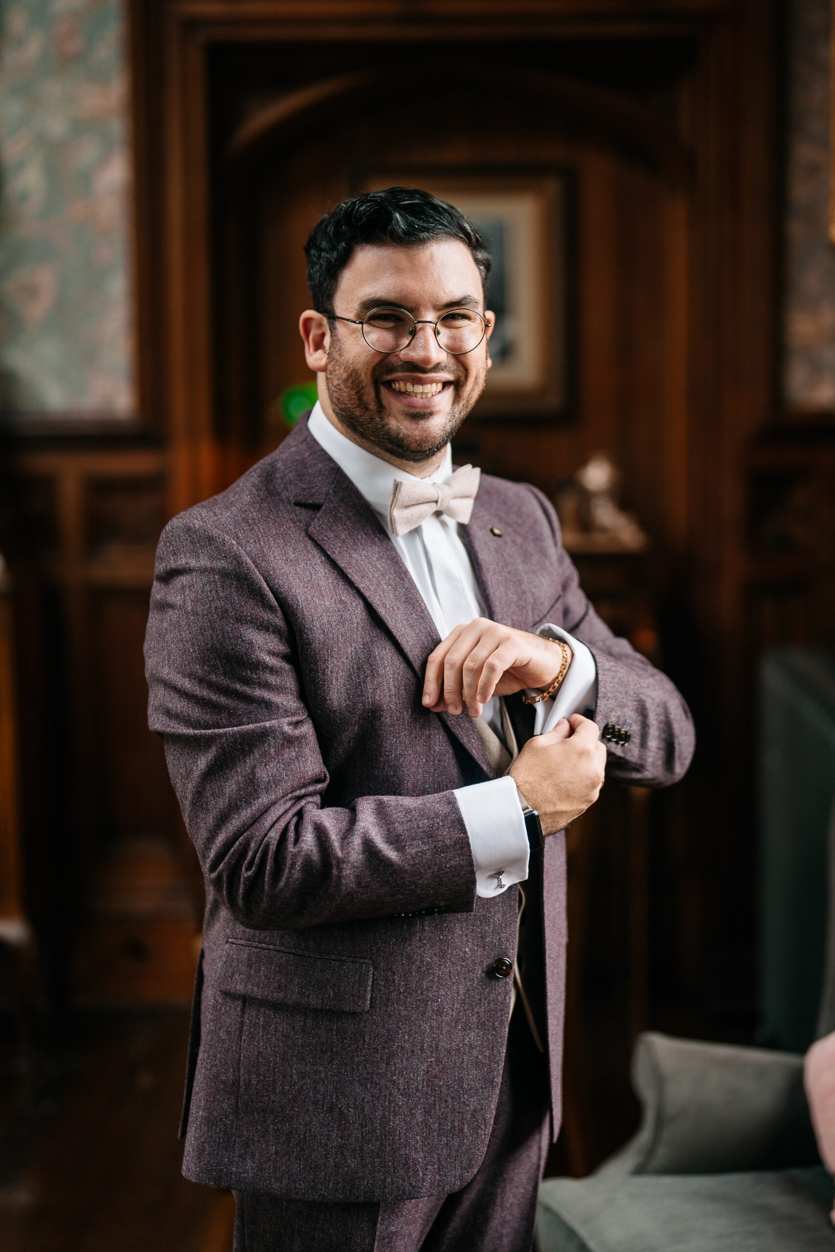 A man in a suit holding a bottle