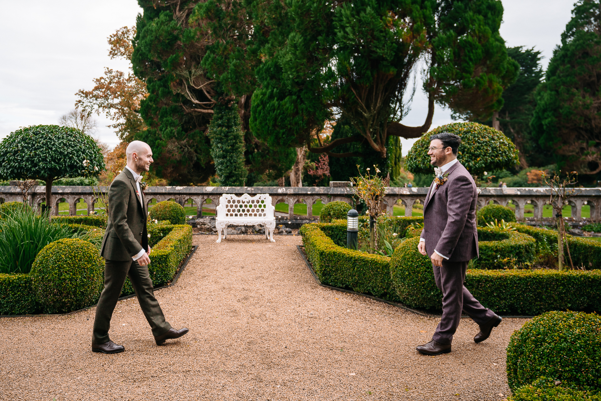 Two men in suits walking in a garden