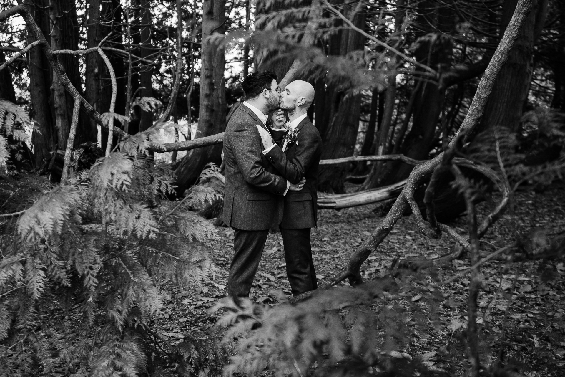 A man and woman kissing in the woods