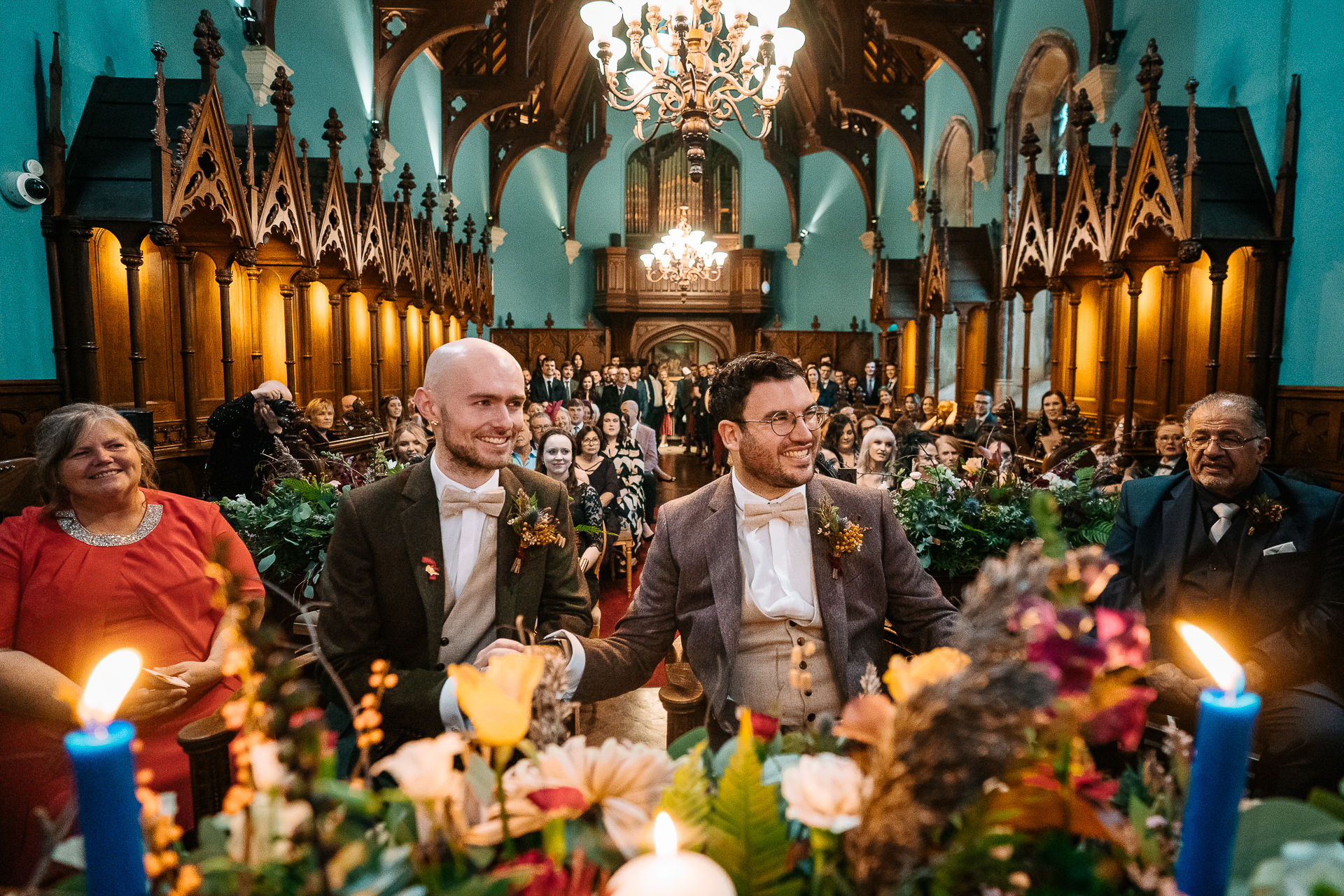 A group of people sitting in a room with flowers and candles