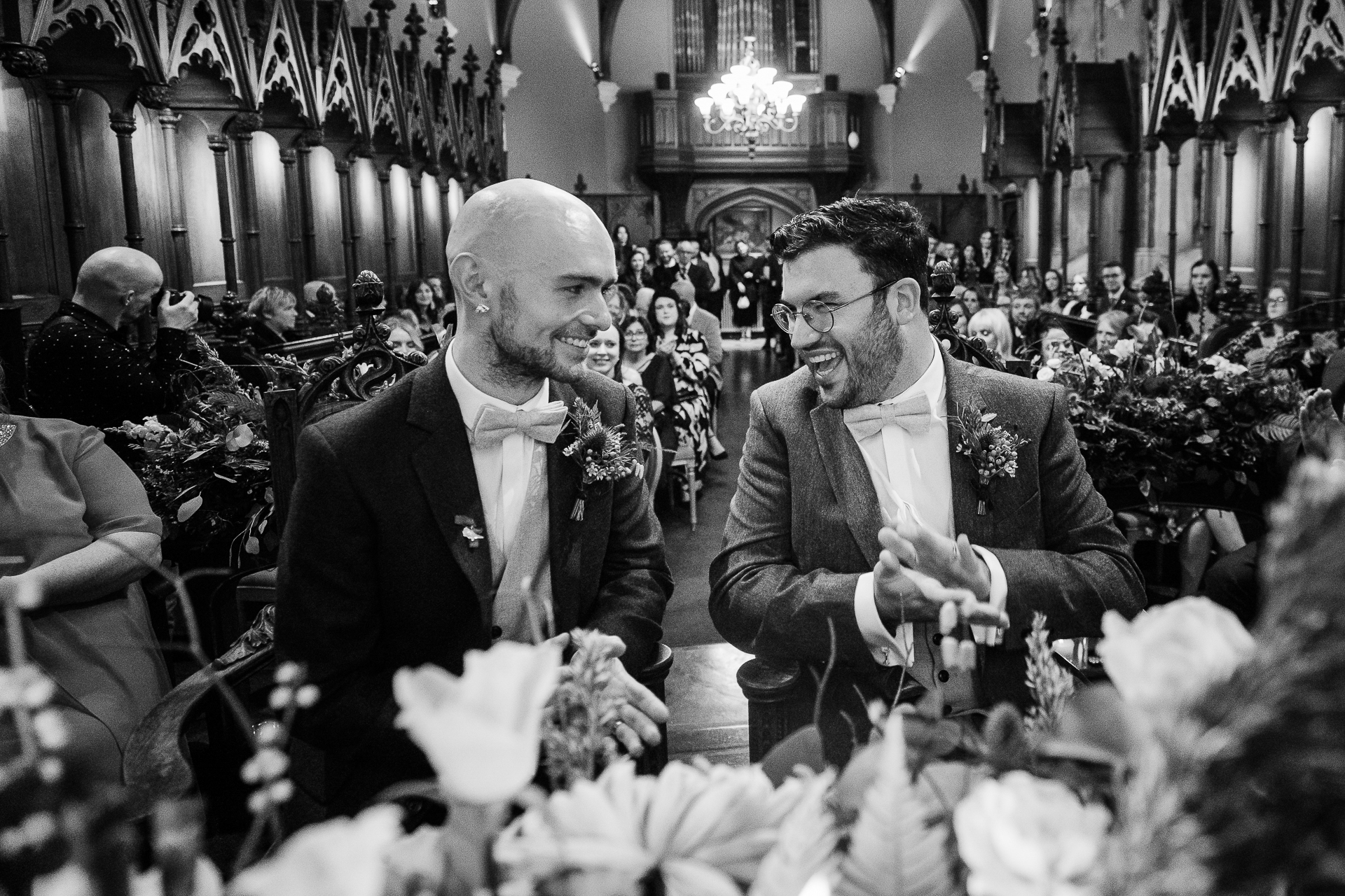 A couple of men sitting at a table with flowers