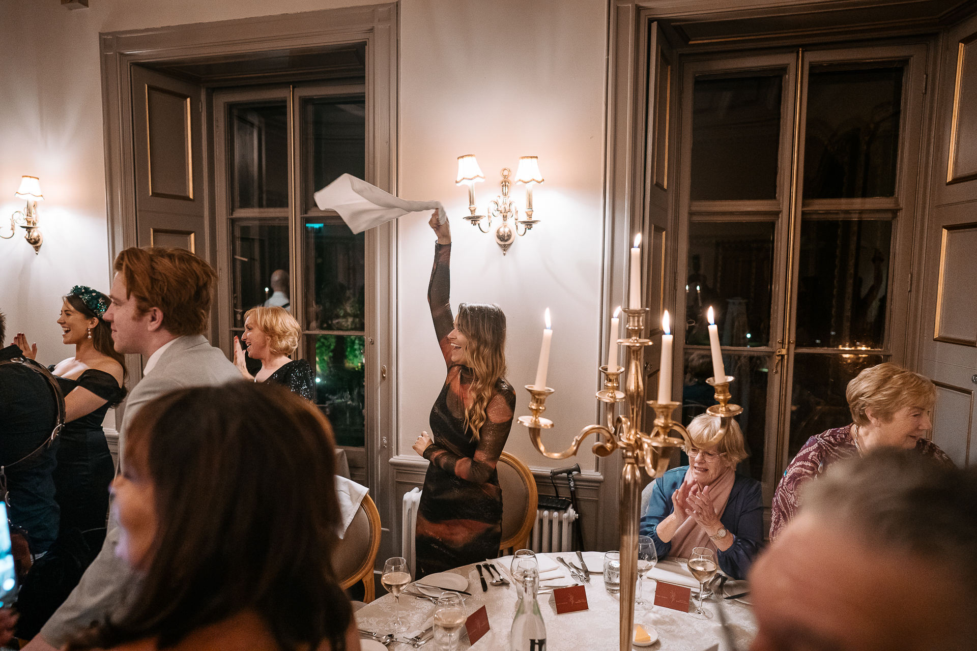 A group of people sitting around a table with candles