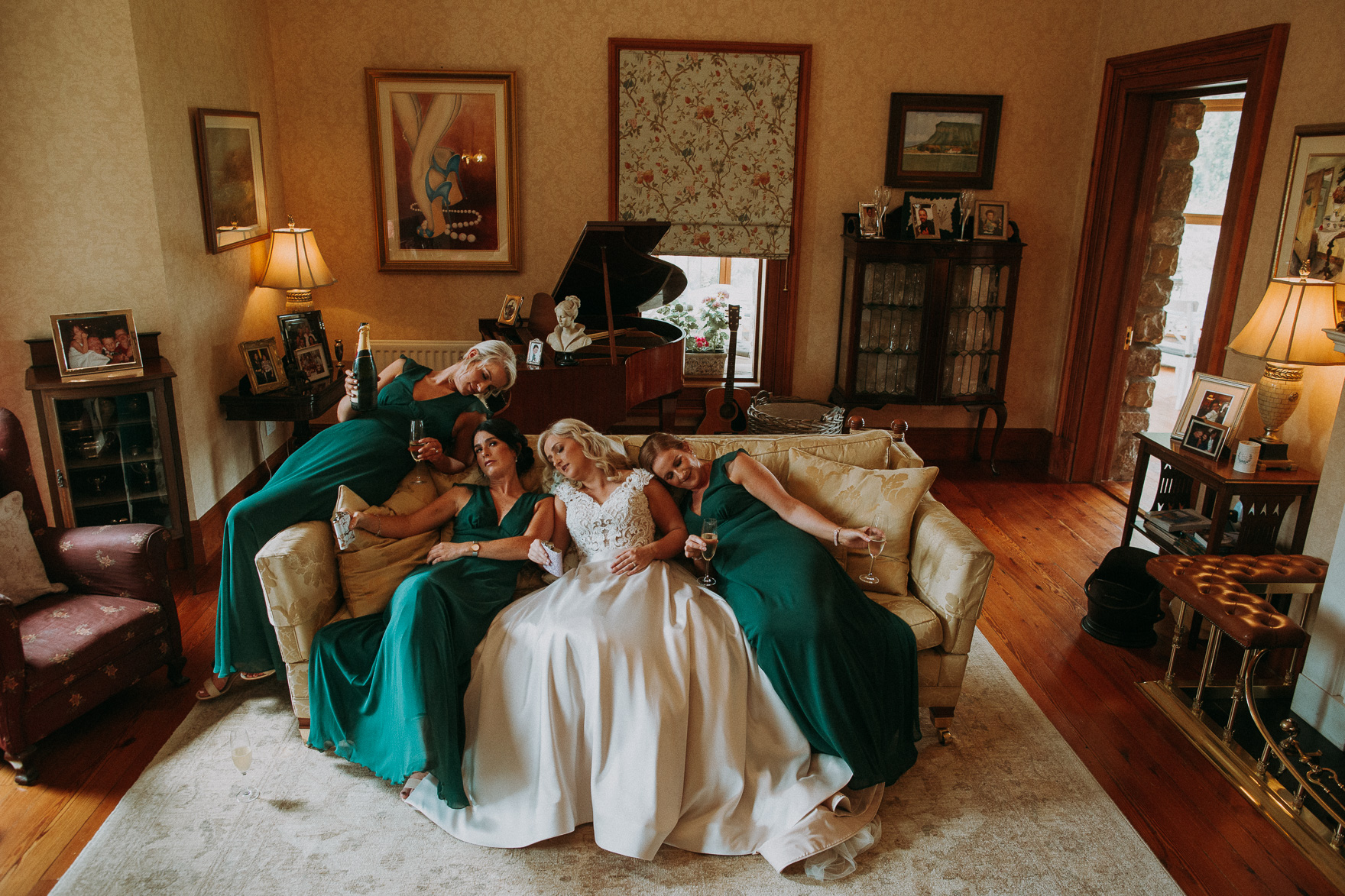bride with bridesmaids lying on the sofa during irish wedding 