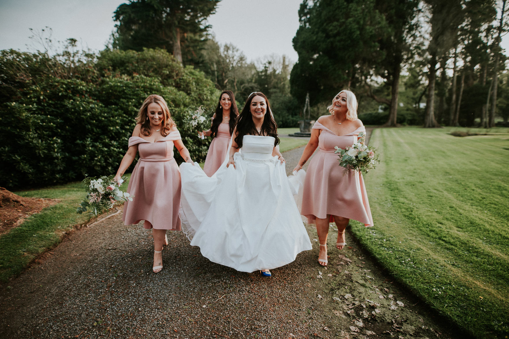 A woman in a wedding dress with braidsmaids in the pink dresses