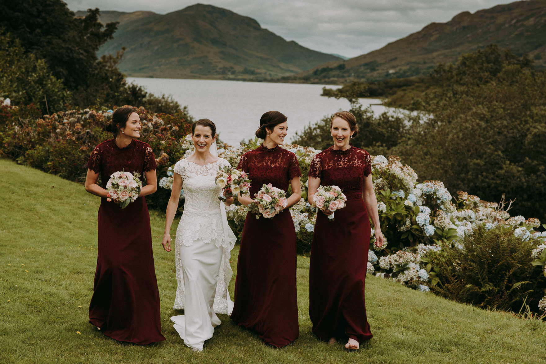 bride and bridesmaids in red dresses in the garden during irish wedding