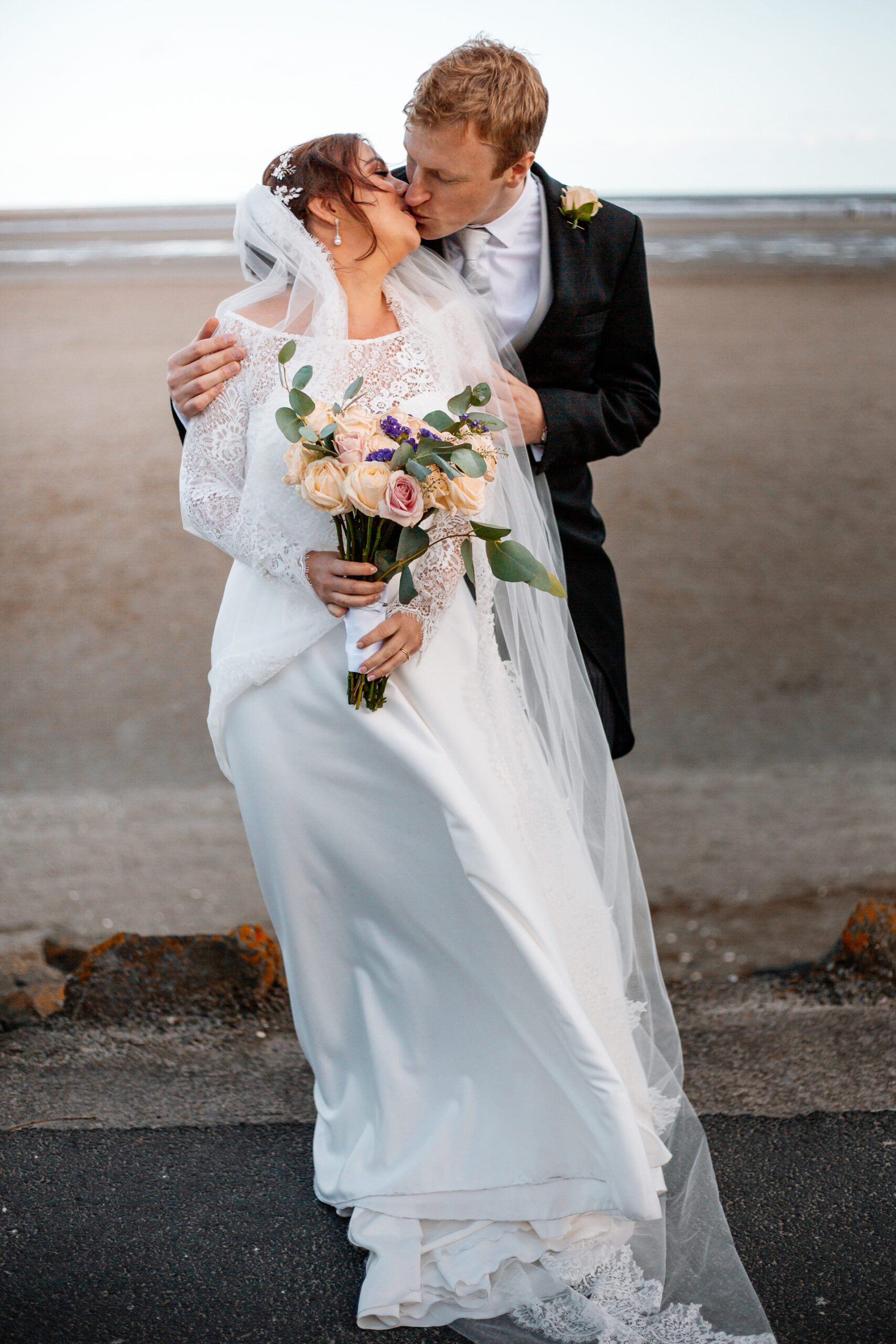 A man and woman kissing on a beach