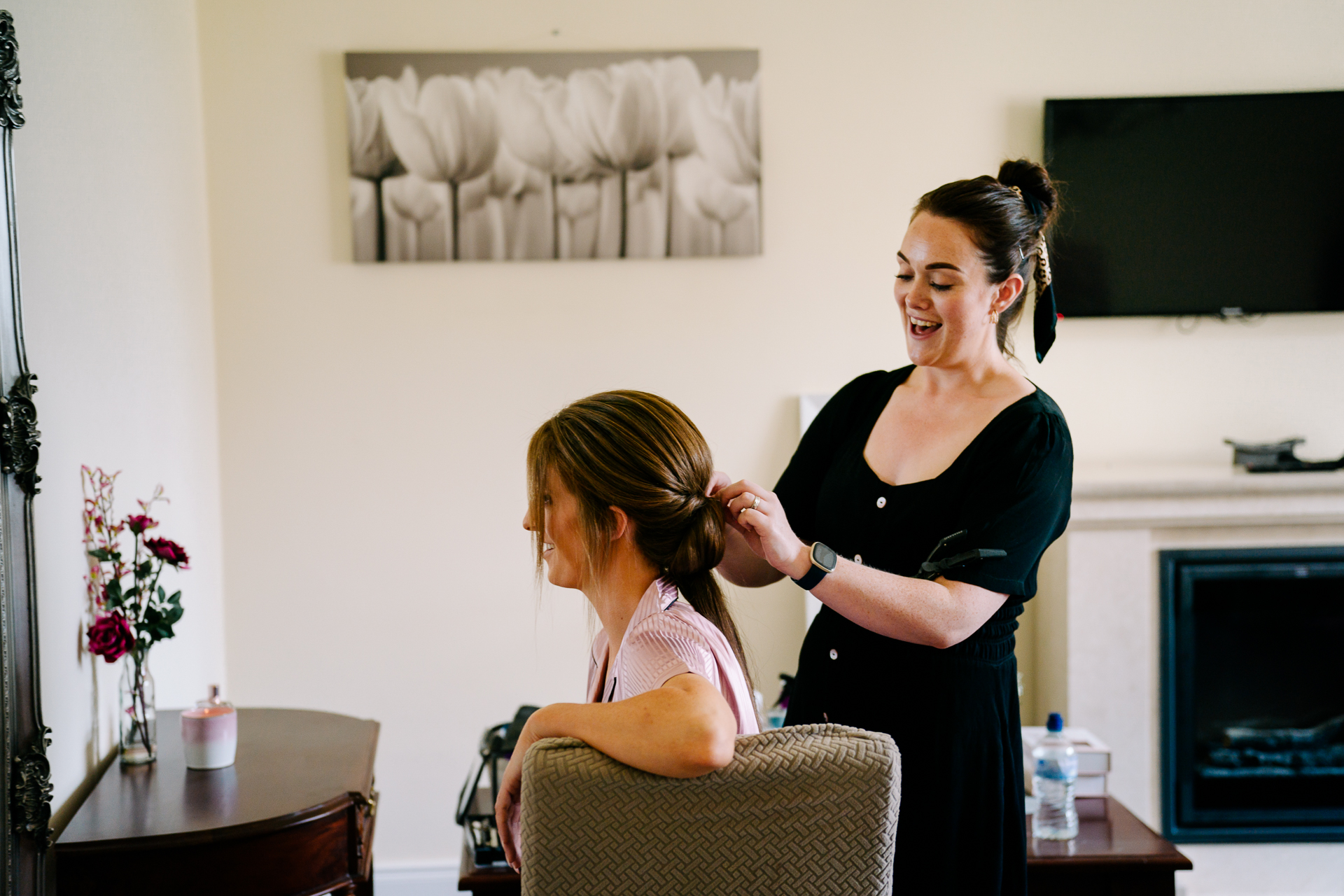 A woman cutting another woman's hair