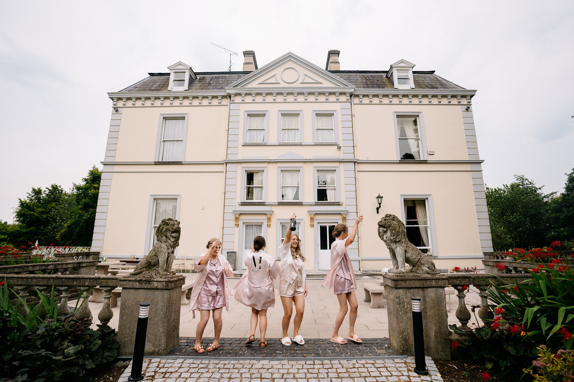 A group of women posing in front of a white building