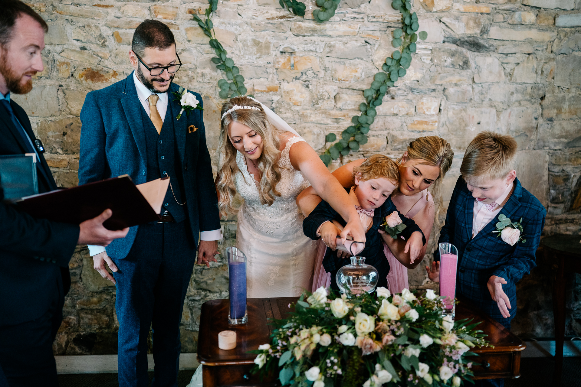 A group of people standing around a table with a person in a dress