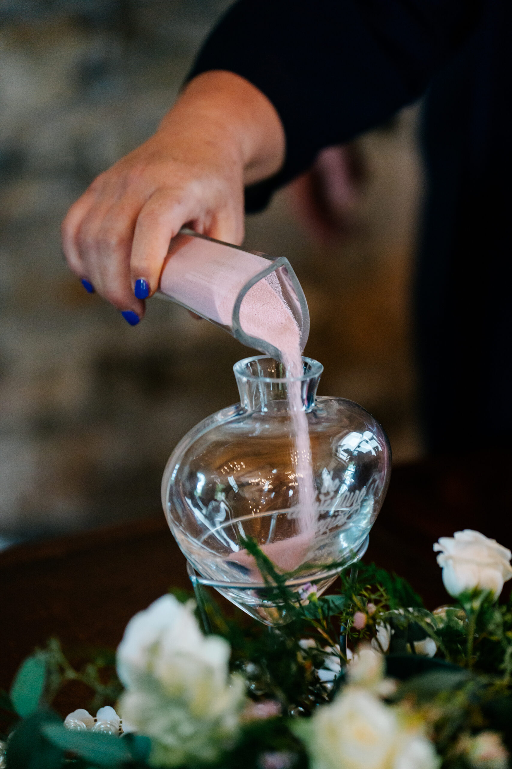 A person pouring a liquid into a glass jar