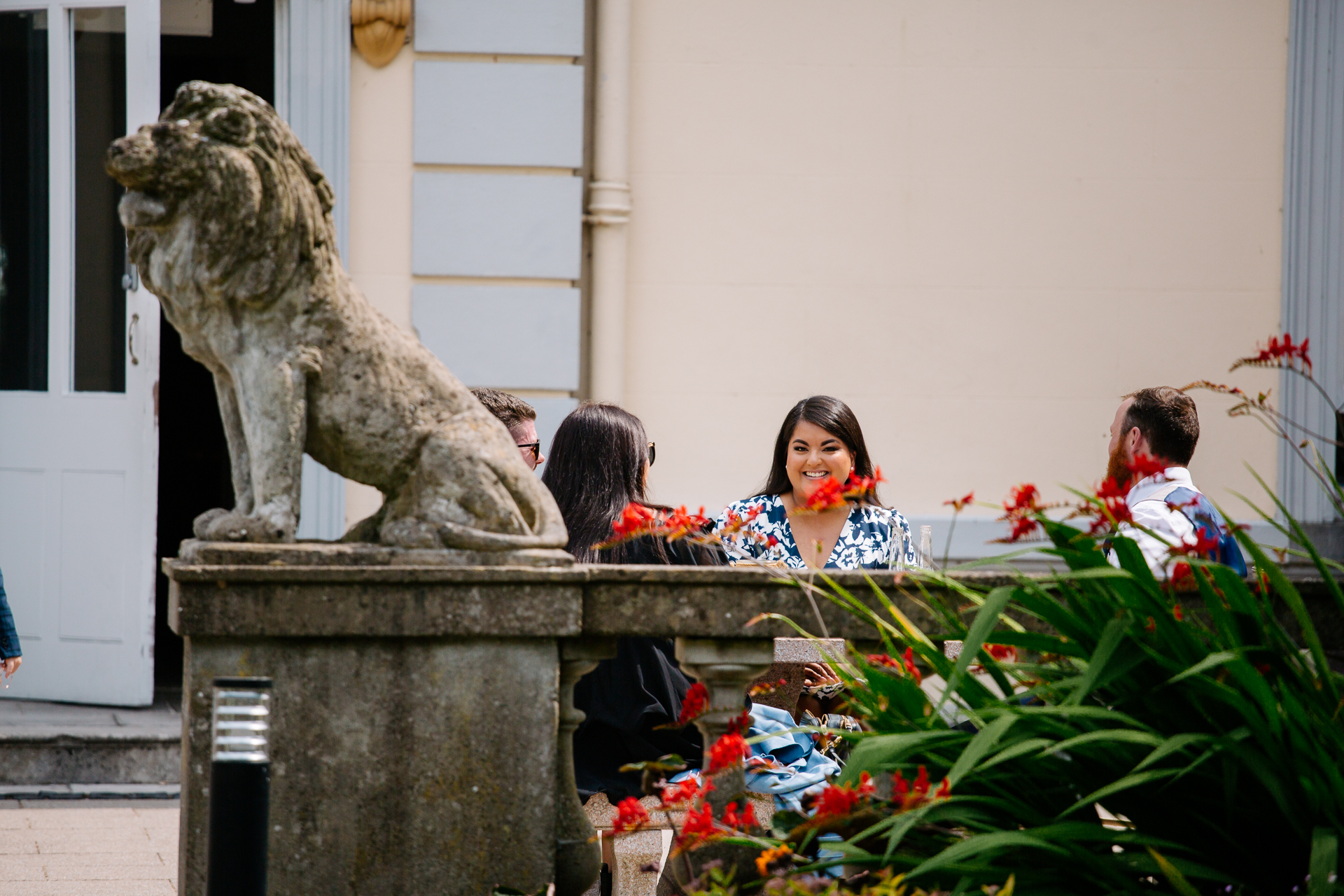 A group of people sitting next to a lion statue