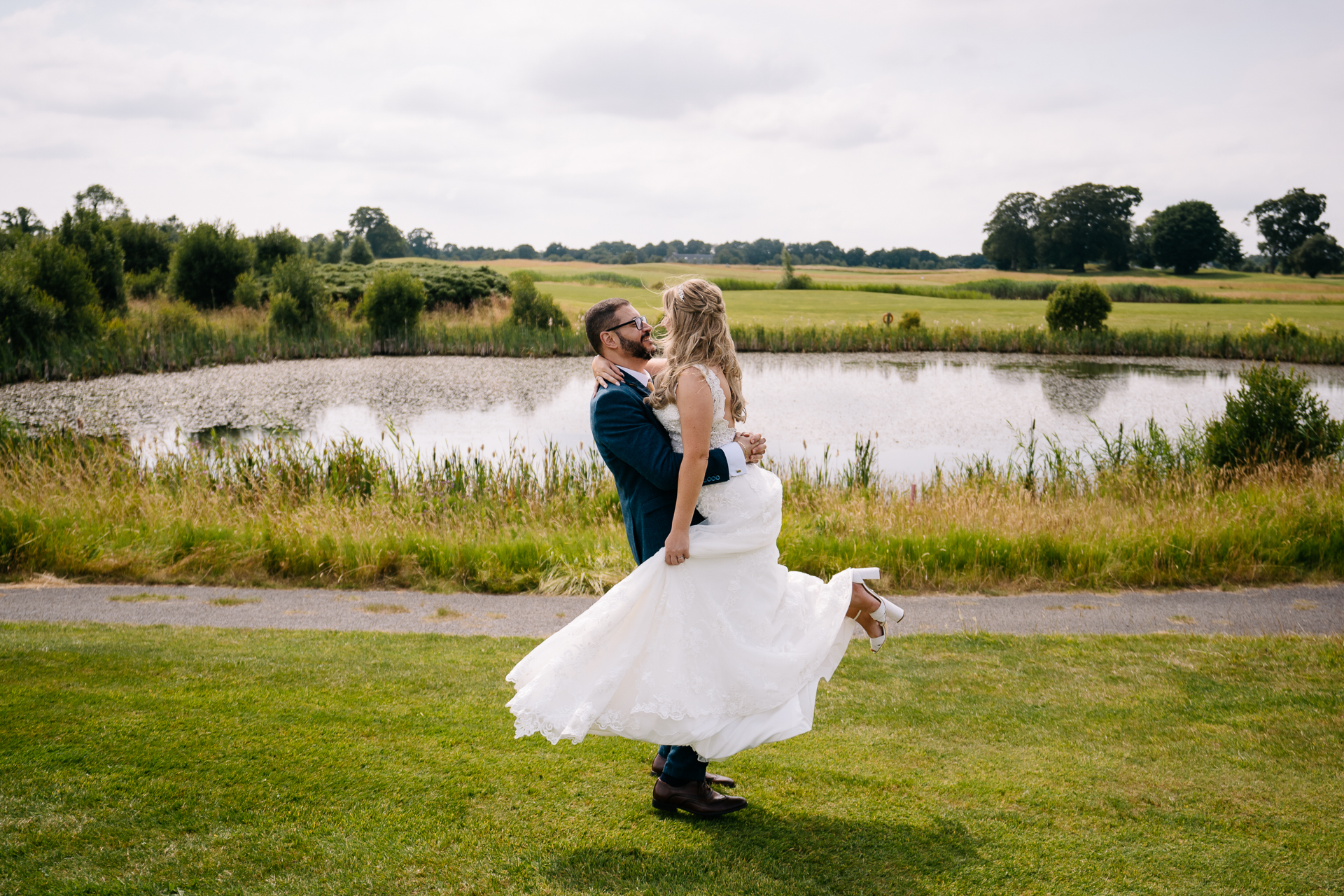 A man and woman kissing in front of a pond