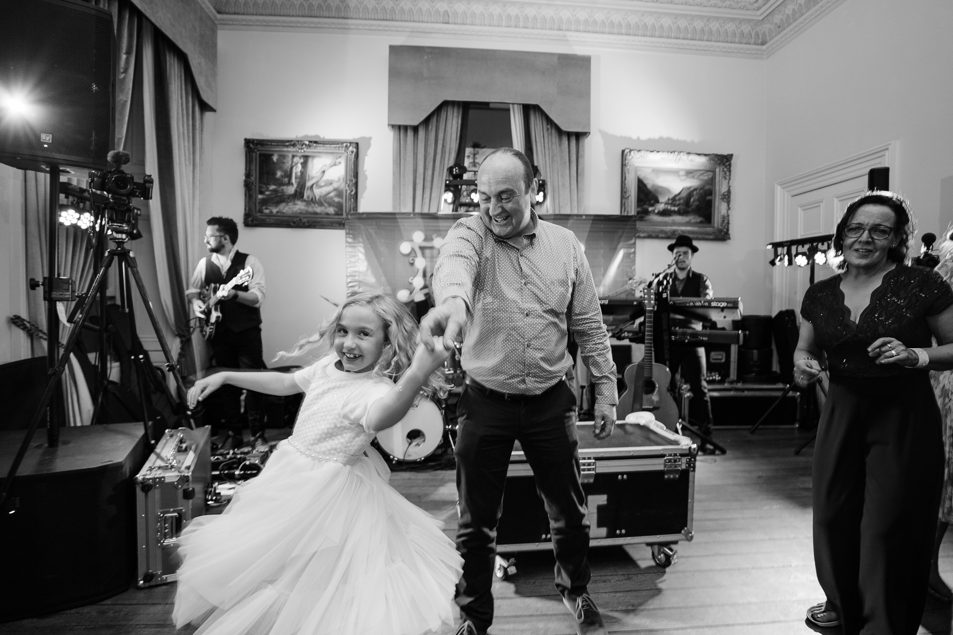 A man and a woman dancing in a room with other people