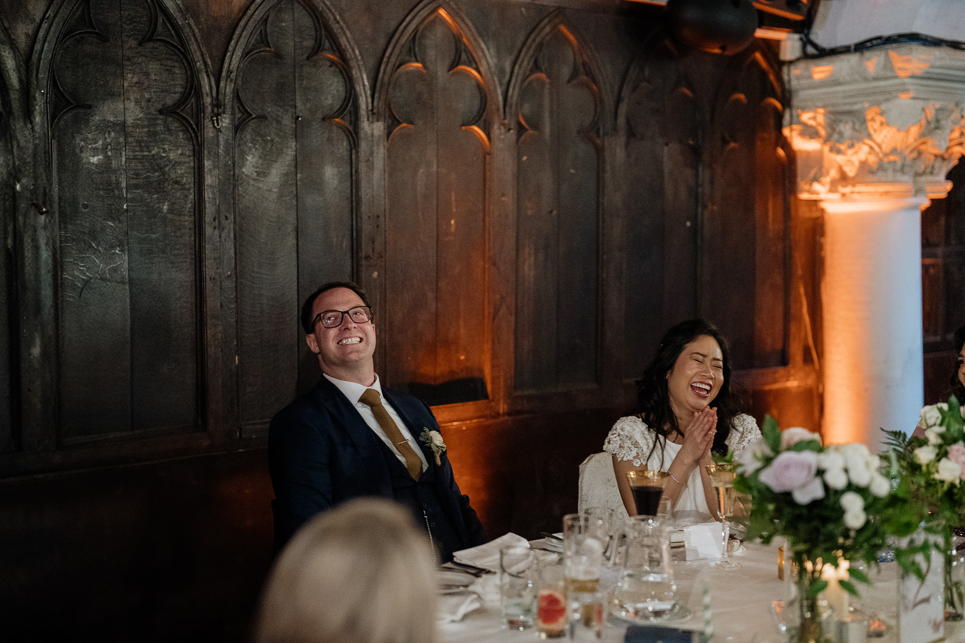 A man and woman sitting at a table with flowers and glasses