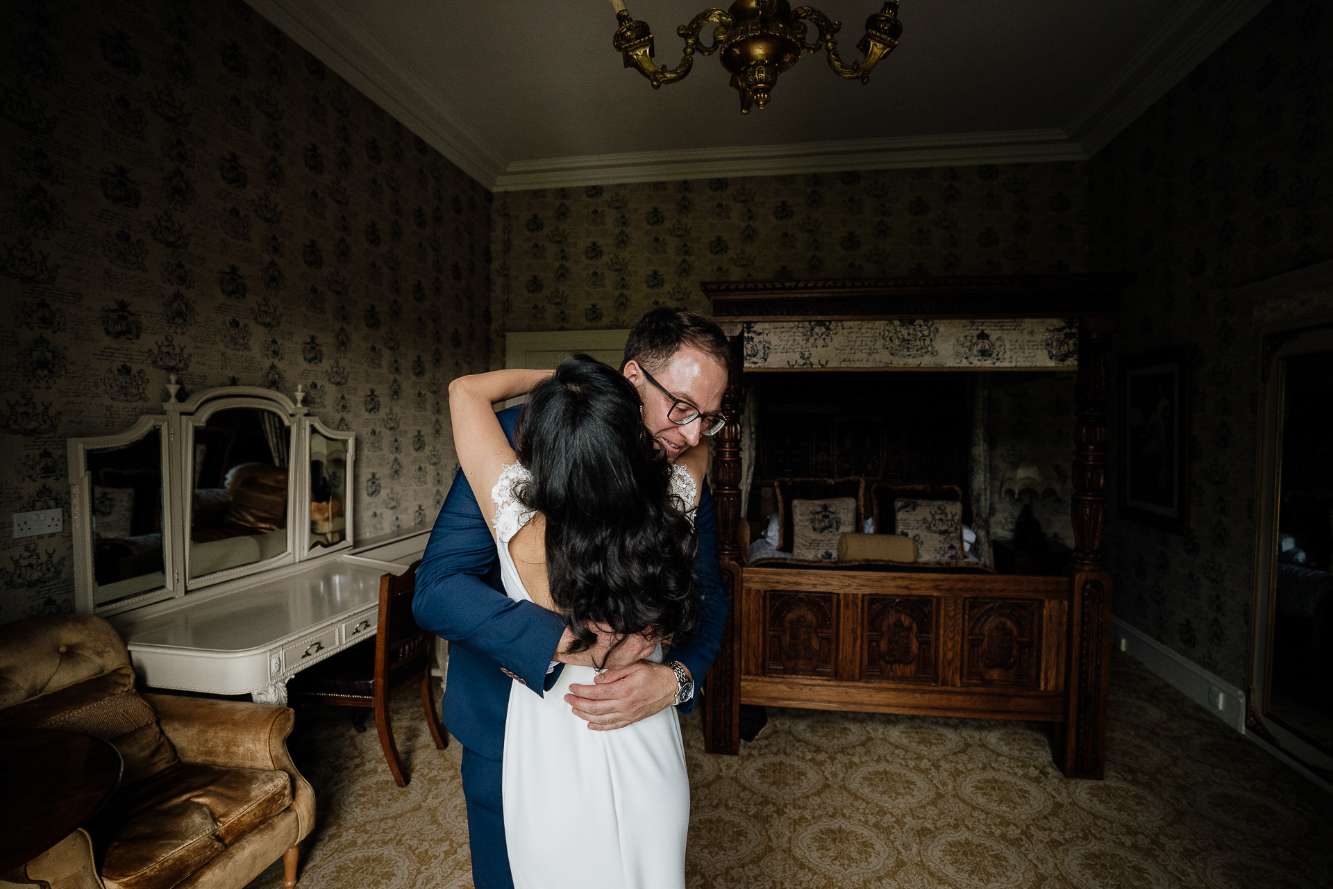 A man and woman kissing in a room with a fireplace