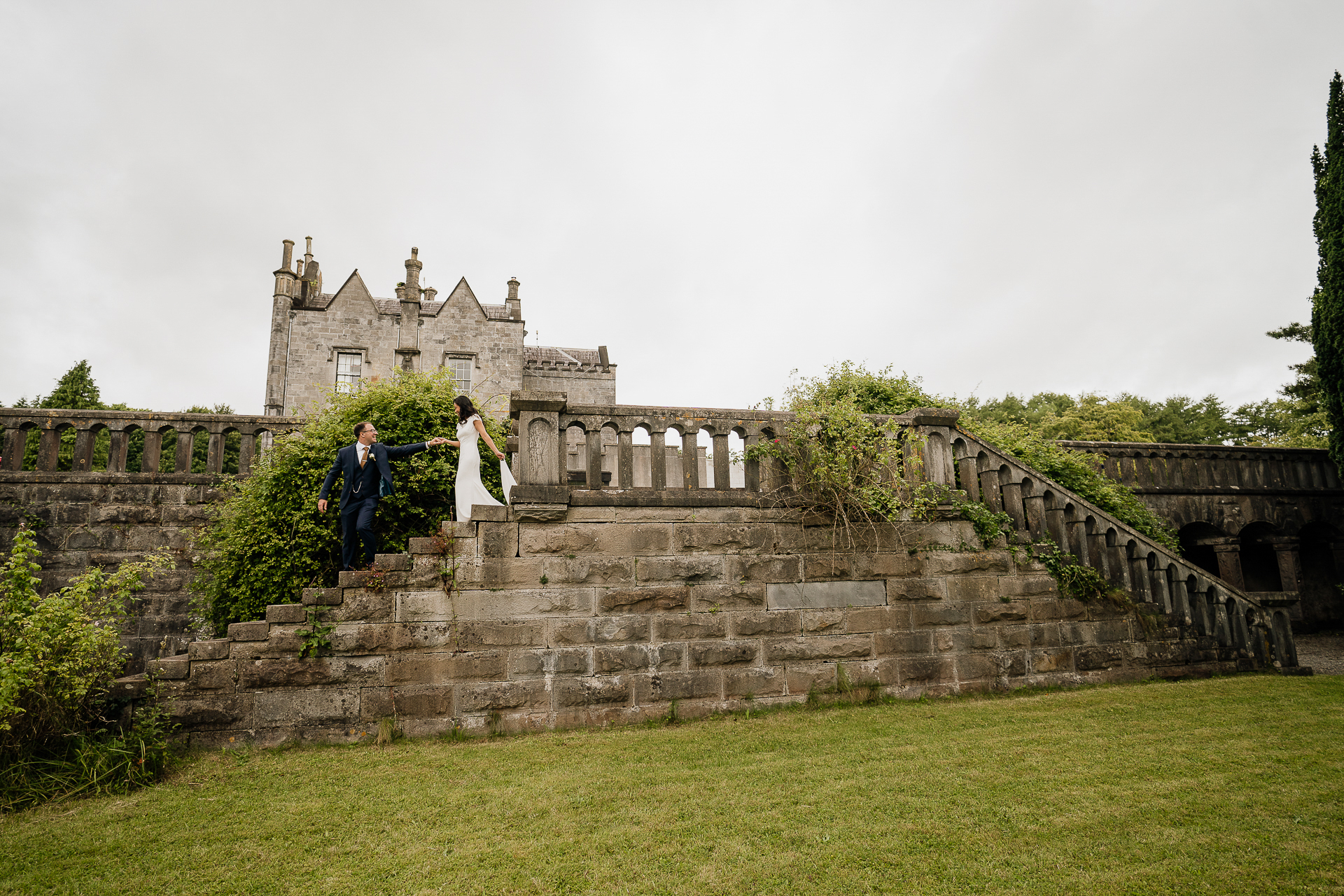 A couple people standing on a stone wall in front of a building