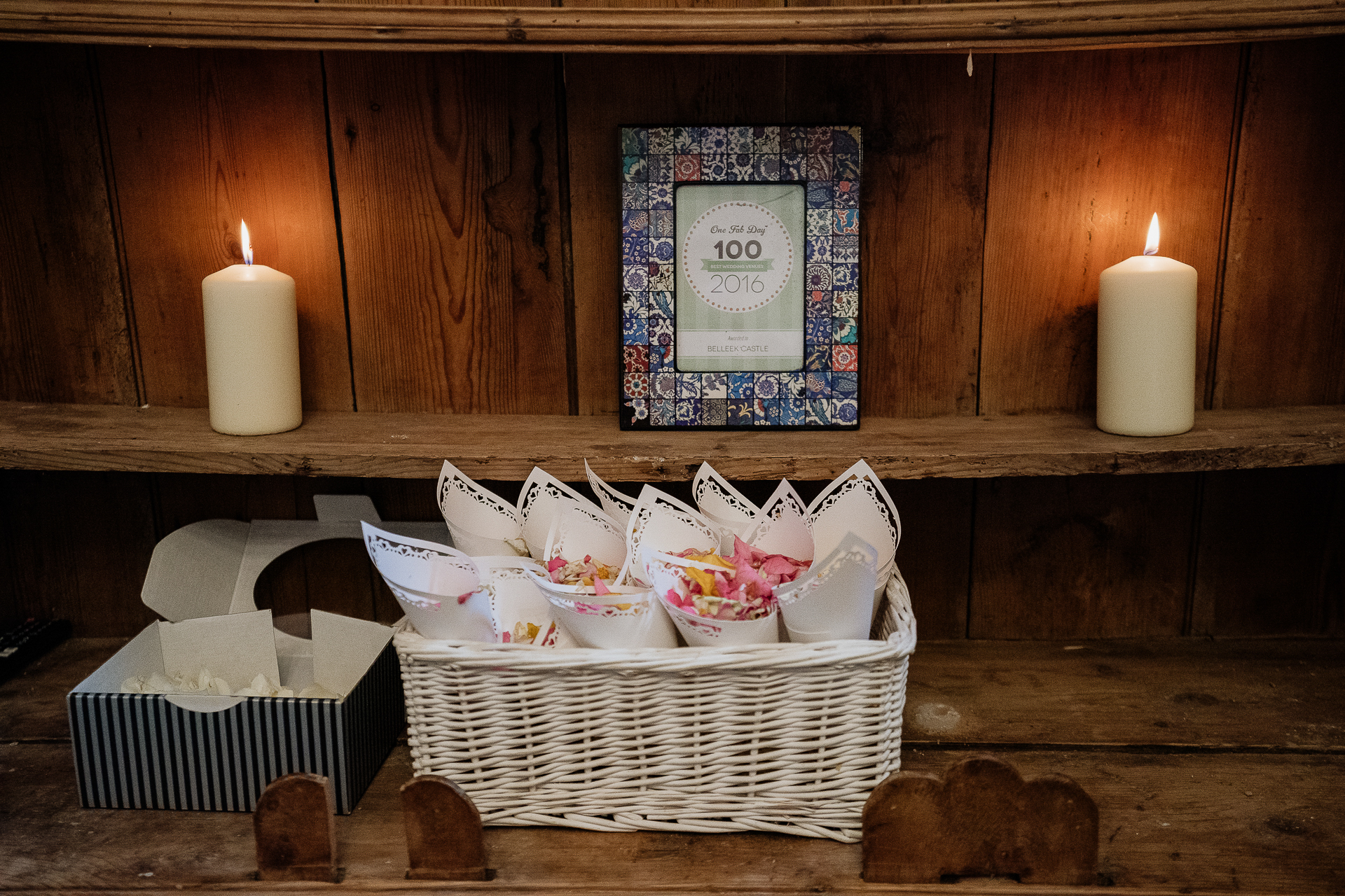 A shelf with candles and a basket of flowers