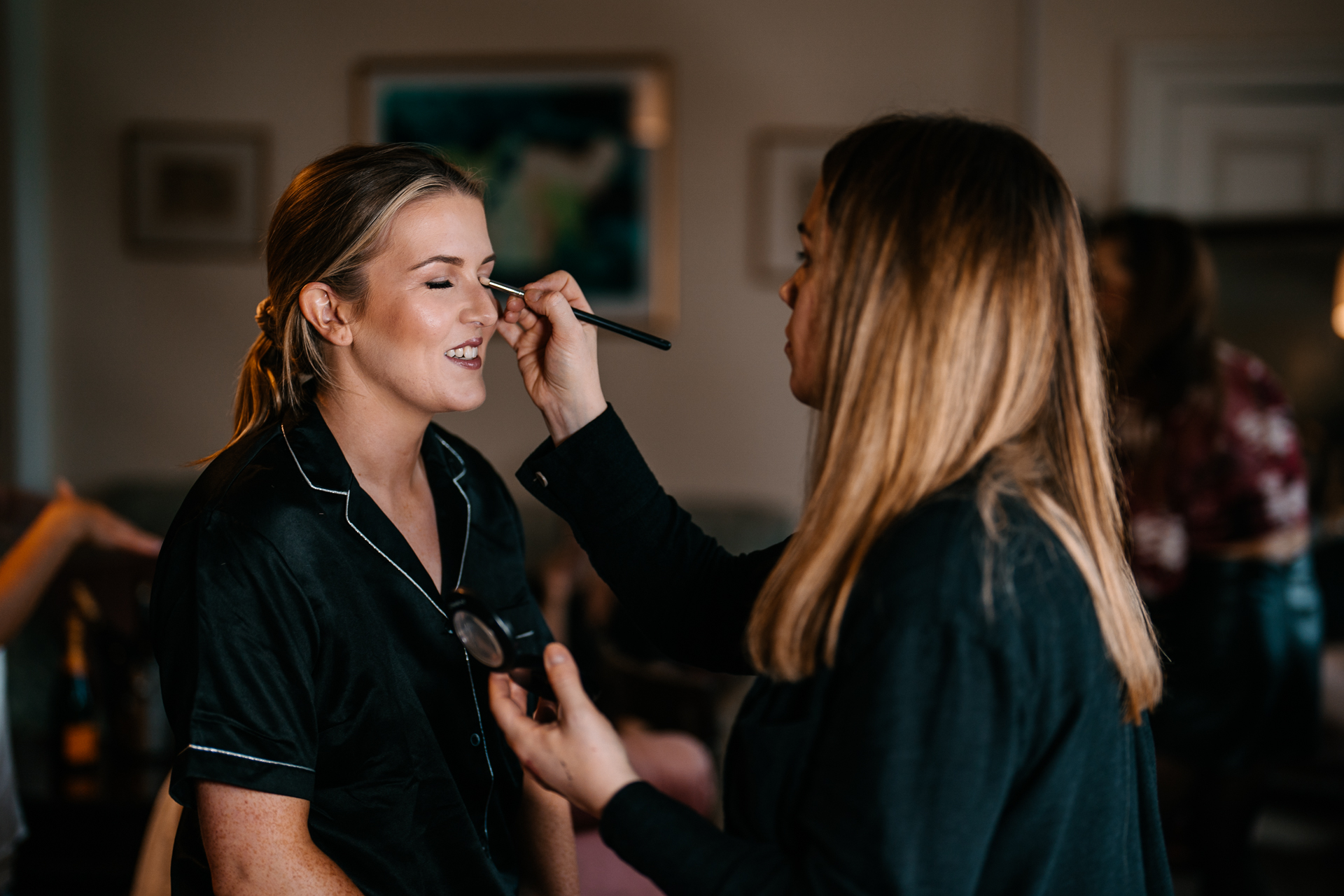 A person with a brush in the mouth and another woman with the hair in a ponytail