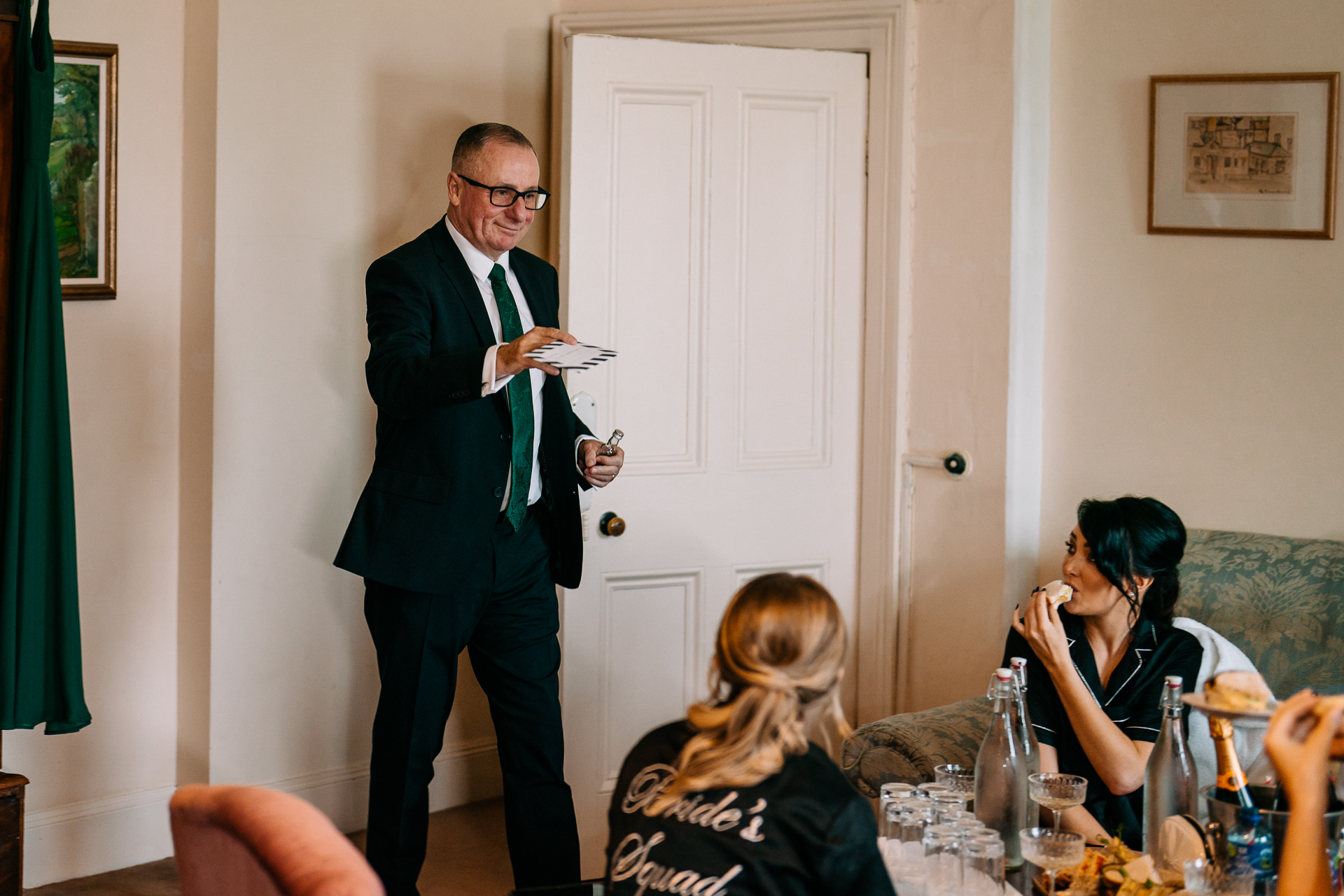 A man in a suit holding a plate of food in front of a group of women