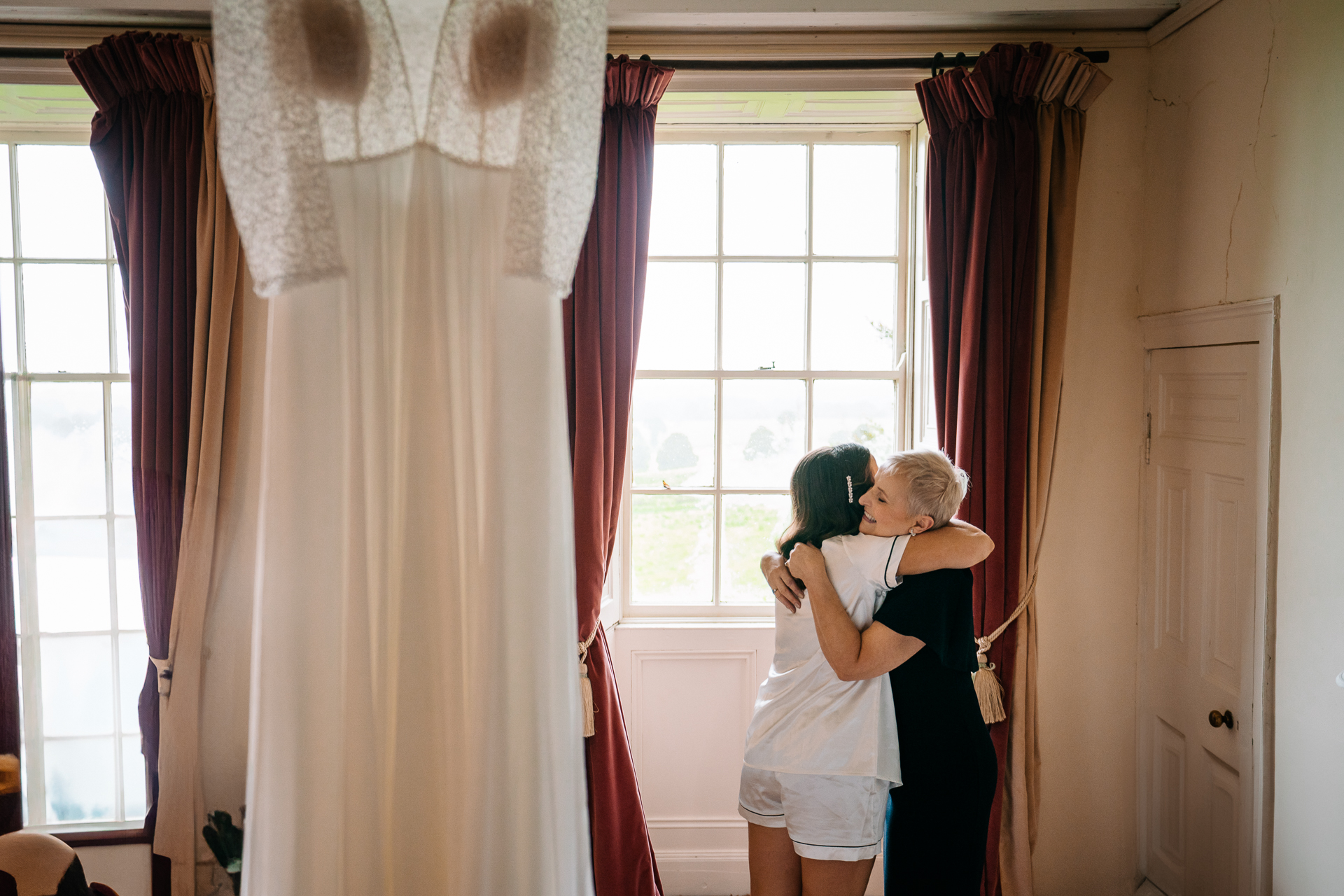 A woman kissing a man in a room with curtains