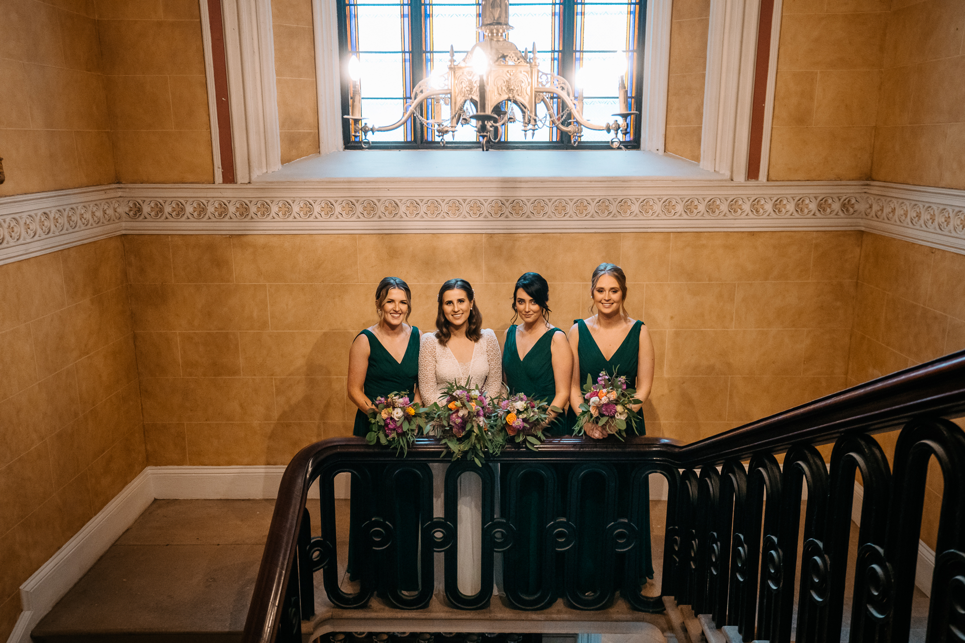 A group of women in formal wear standing on a podium in front of a window